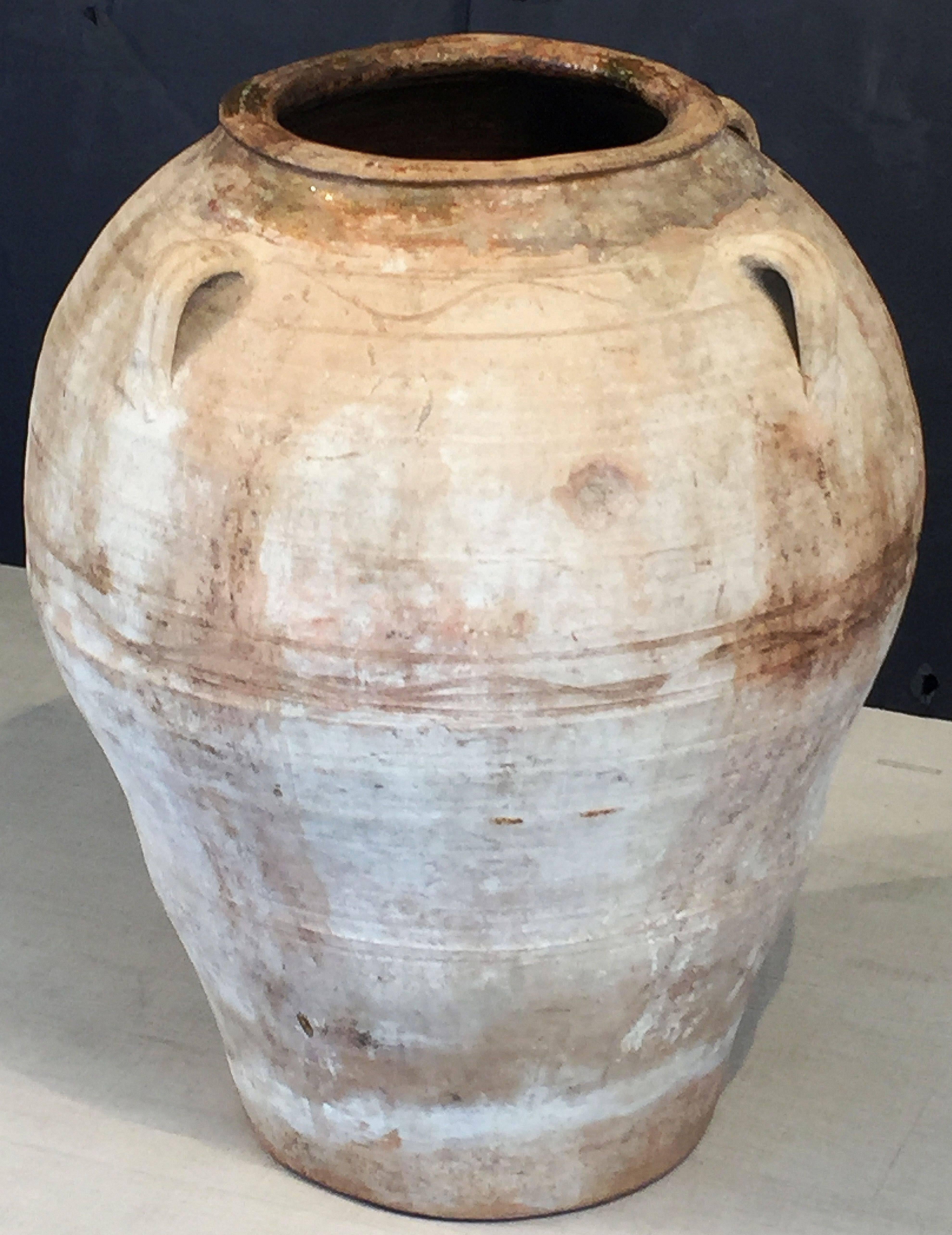 A handsome large Spanish garden pot or oil jar, featuring a glazed rolled-edge top over a cylindrical body with four handles, and functional as a garden ornament, fountain, or planter.

Other similarly-styled pots available in a variety of sizes -