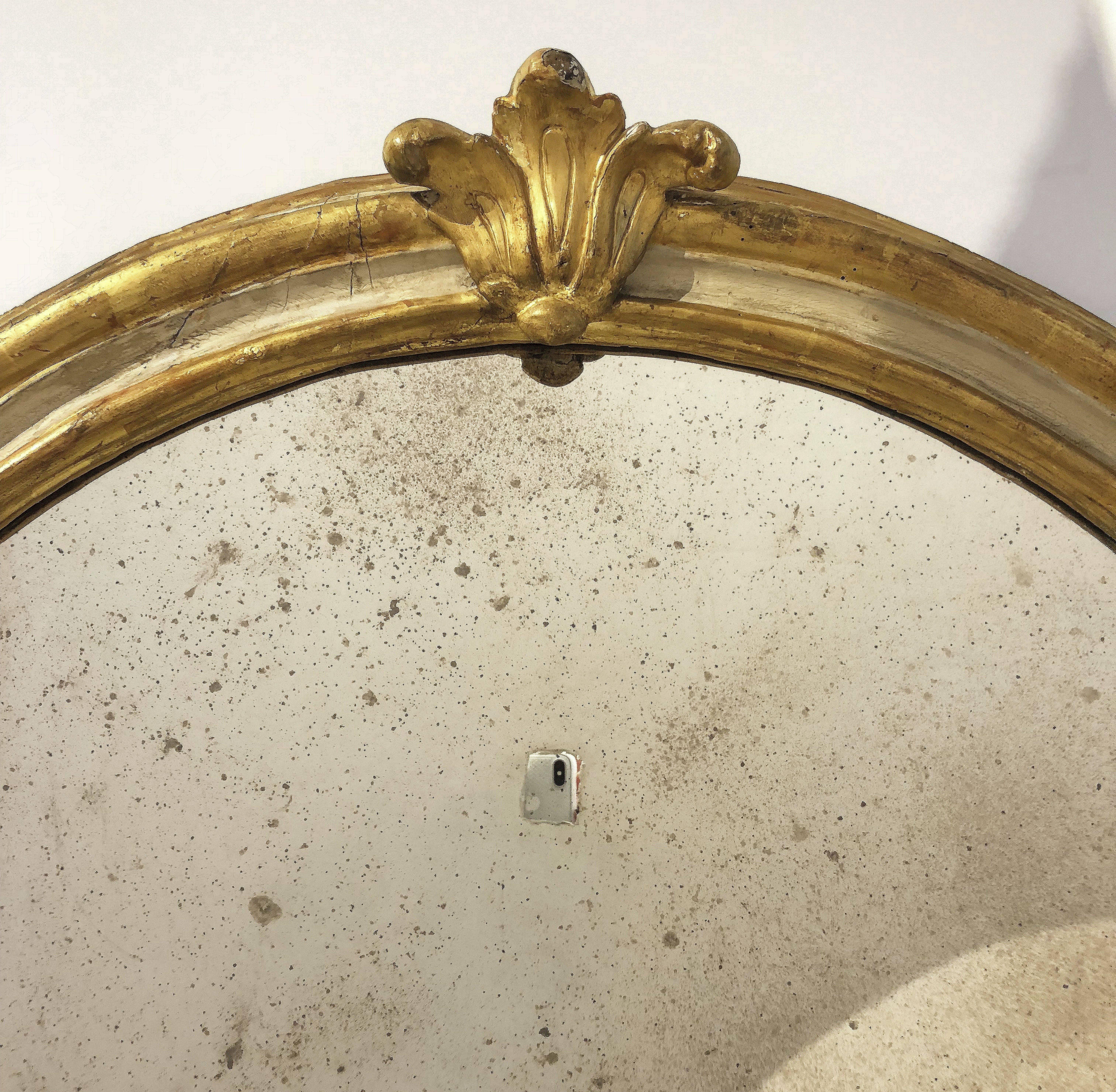 A fine Italian large wall mirror featuring a moulded surround with a beautiful patinated gold-leaf.

Dimensions: H 65 inches x W 37 inches.

