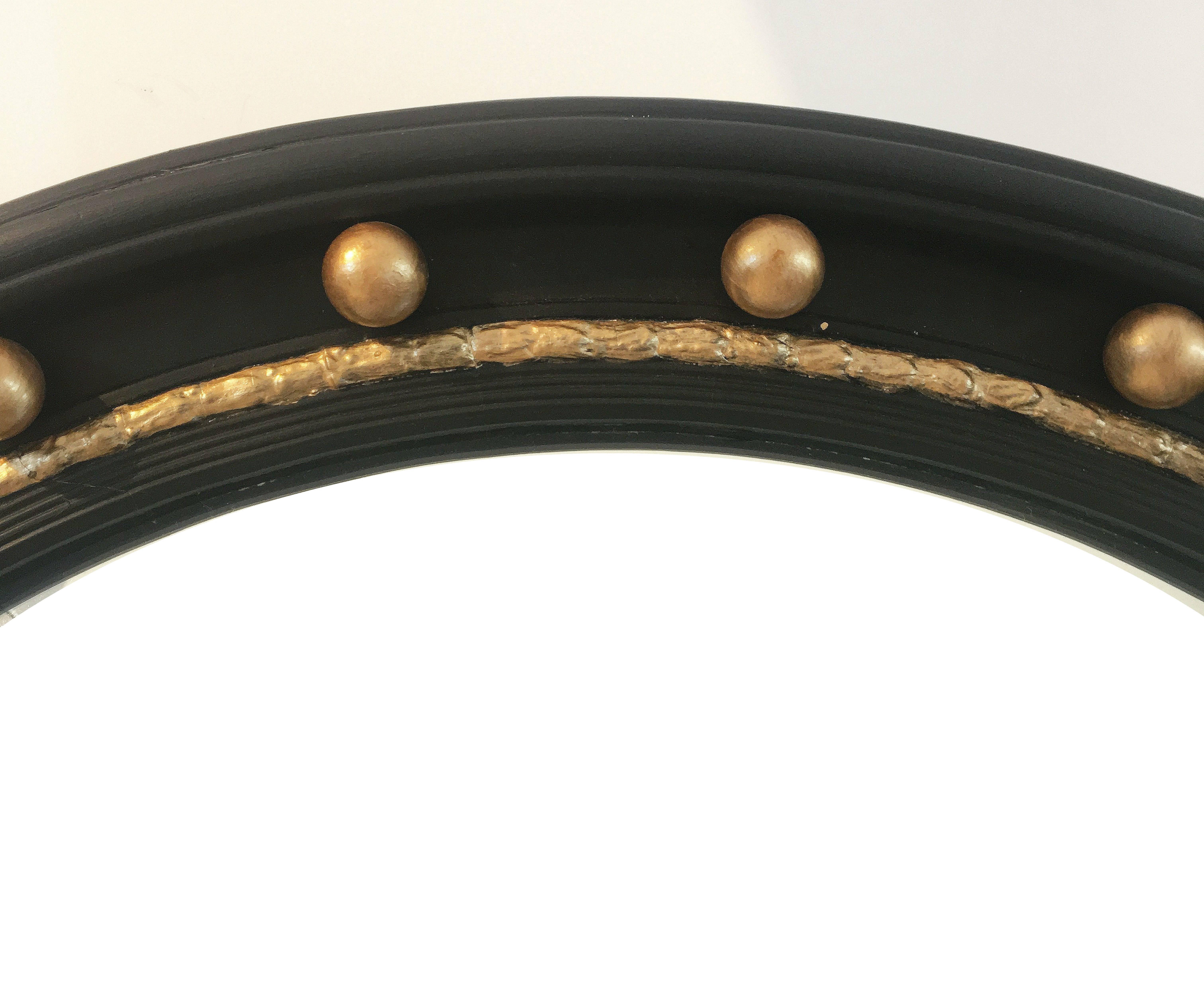 A fine English round convex mirror featuring a Regency design of a moulded, ebonised frame with gilt balls around the circumference.

Diameter is 24 1/2 inches