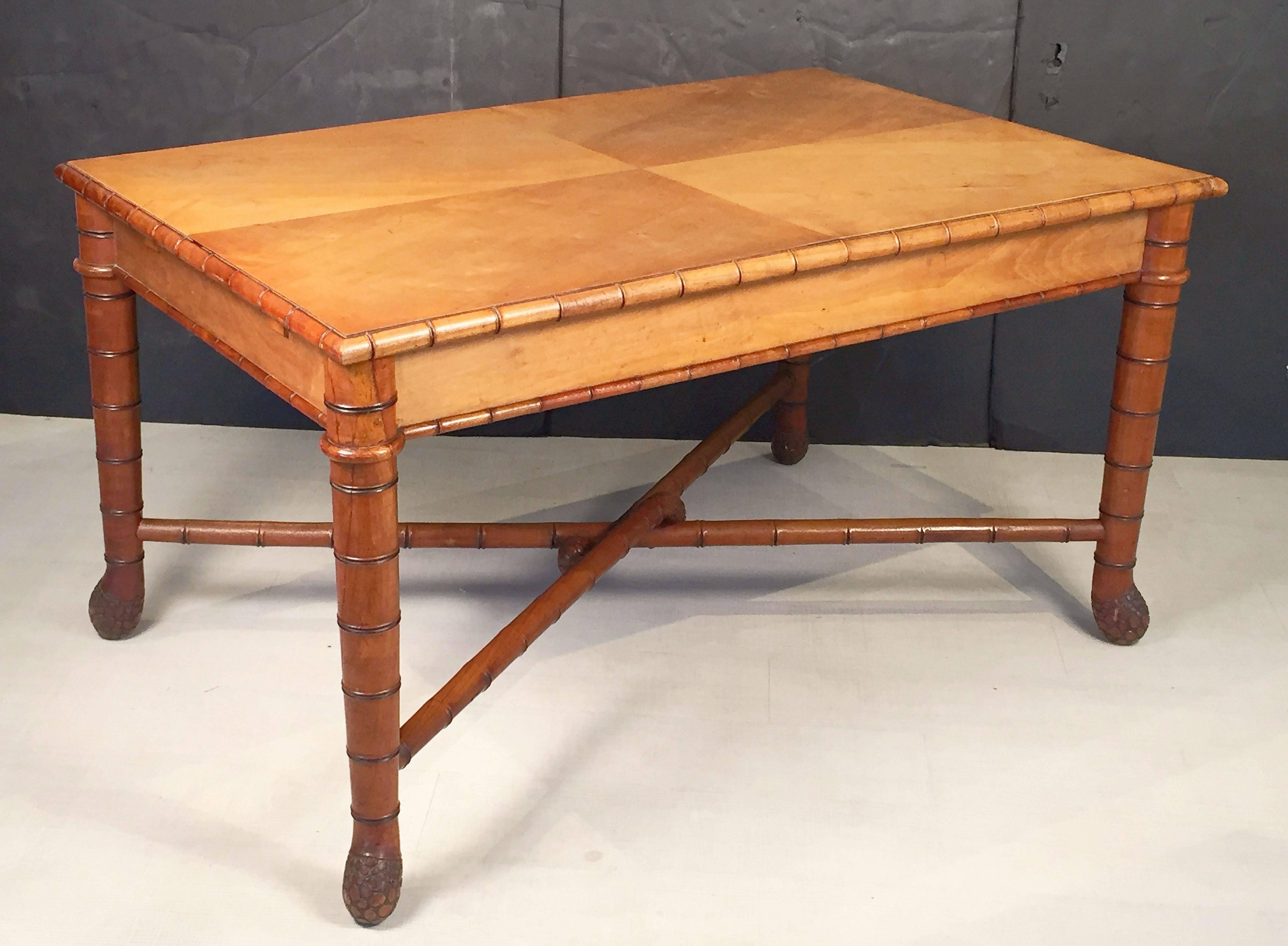 A fine large faux bamboo library table from Italy, featuring a moulded rectangular top over a frieze with a faux bamboo turned wood trim, over a four-legged stretcher with a stylish bamboo root design.