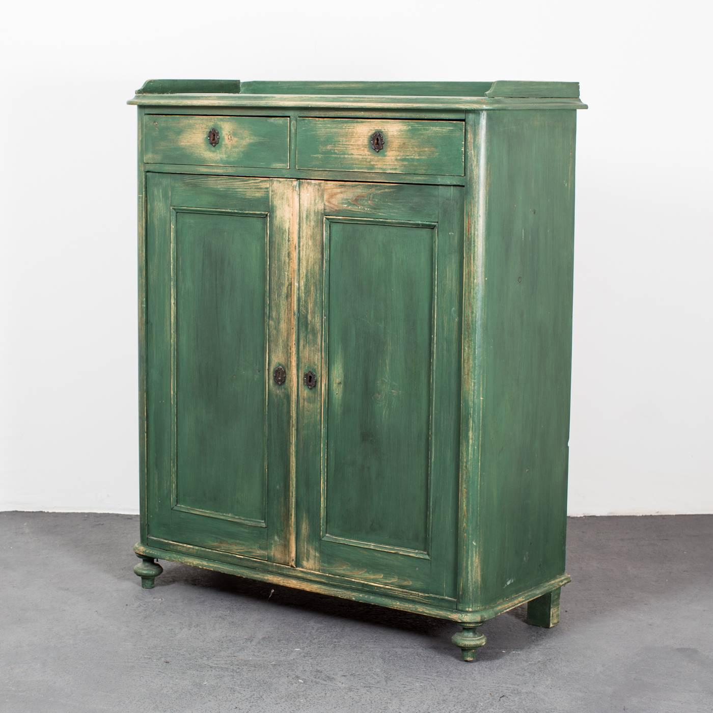 A sideboard made during the 19th century in Sweden. Two drawers below the rail edged top and cabinets with two doors with three shelved interior. Repainted in a subtle green.

