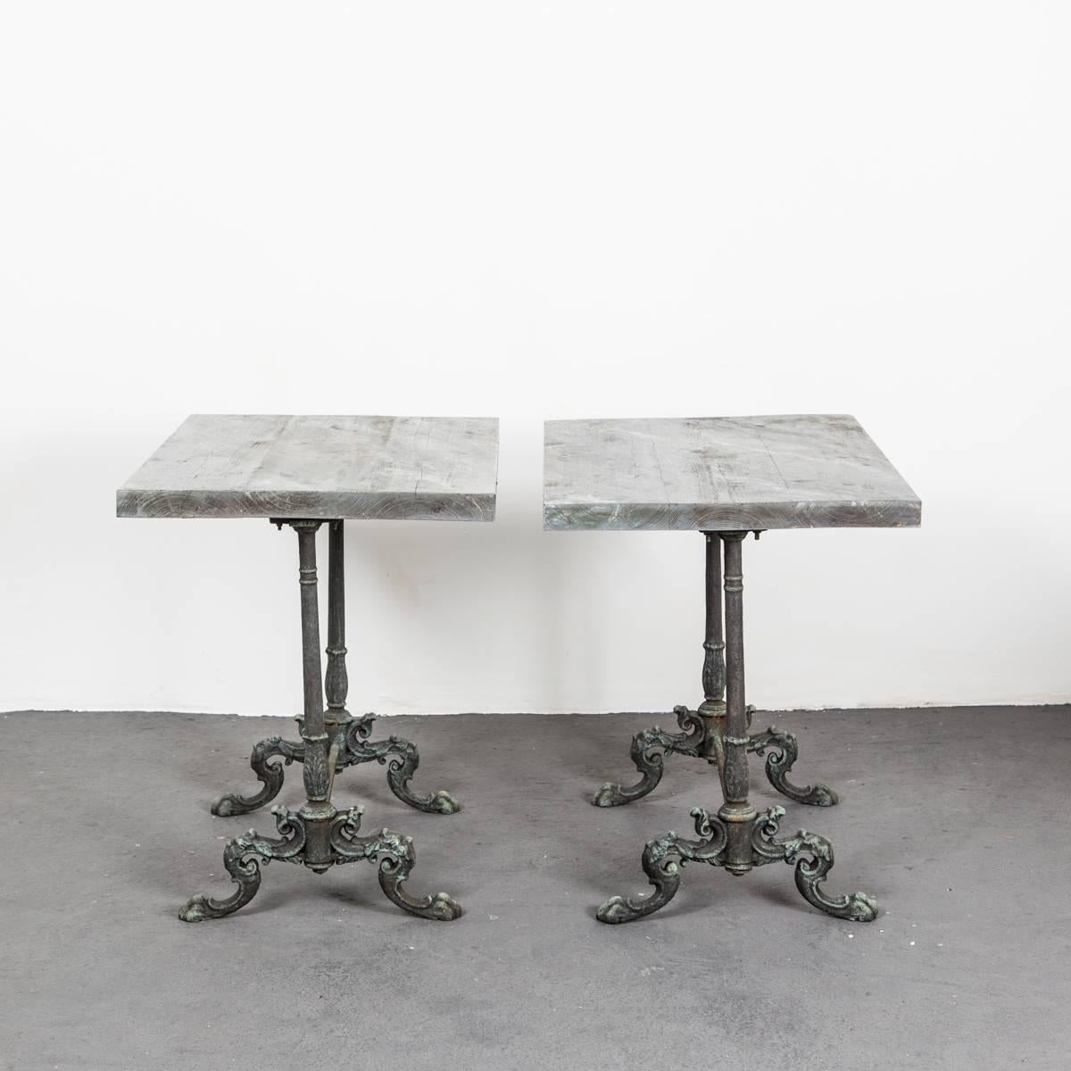 A pair of green patinated cast iron table with tops made from faux stone painted wooden tops. The bases most likely from the end of 19th century. Tops new.