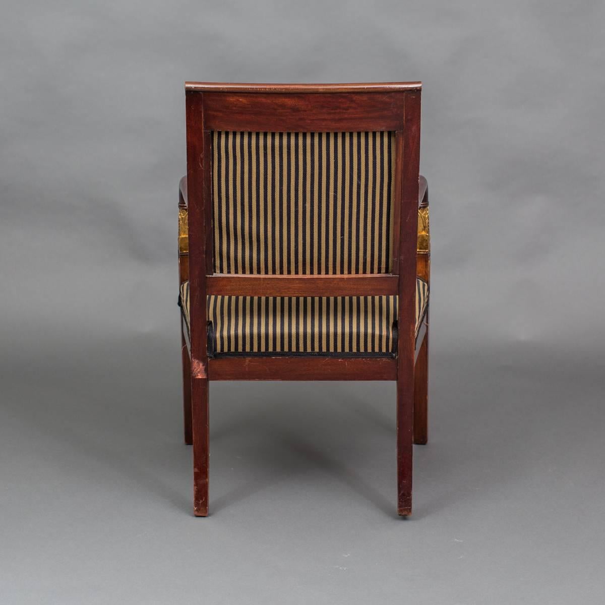 Armchair French 19th Century Mahogany Gilded Details Empire Style France. An armchair made in the Empire style during the 19th Century. Frame made in dark mahogany with gilded details, restored. Upholstered back and seat in a dark blue and golden