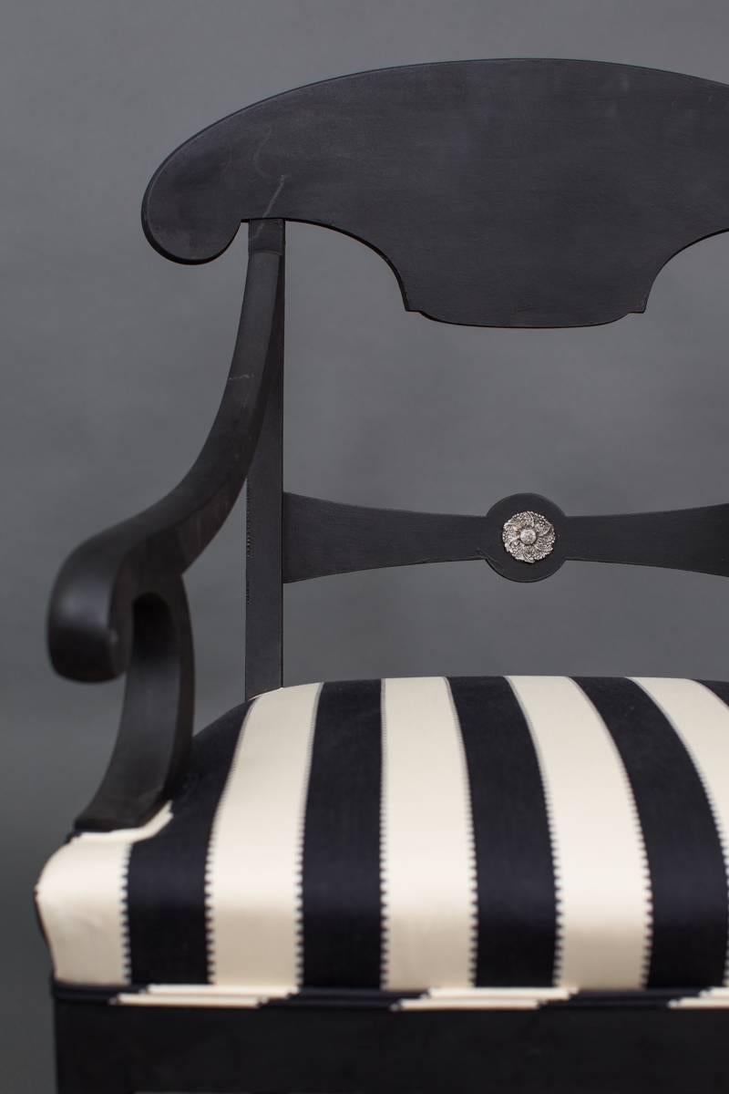 An armchair made in the Karl Johan/Empire style. Frame in restored black paint with a silver colored flower decor. Sable legs front and back. Seat upholstered in a black and white striped Pierre Frey fabric.
    