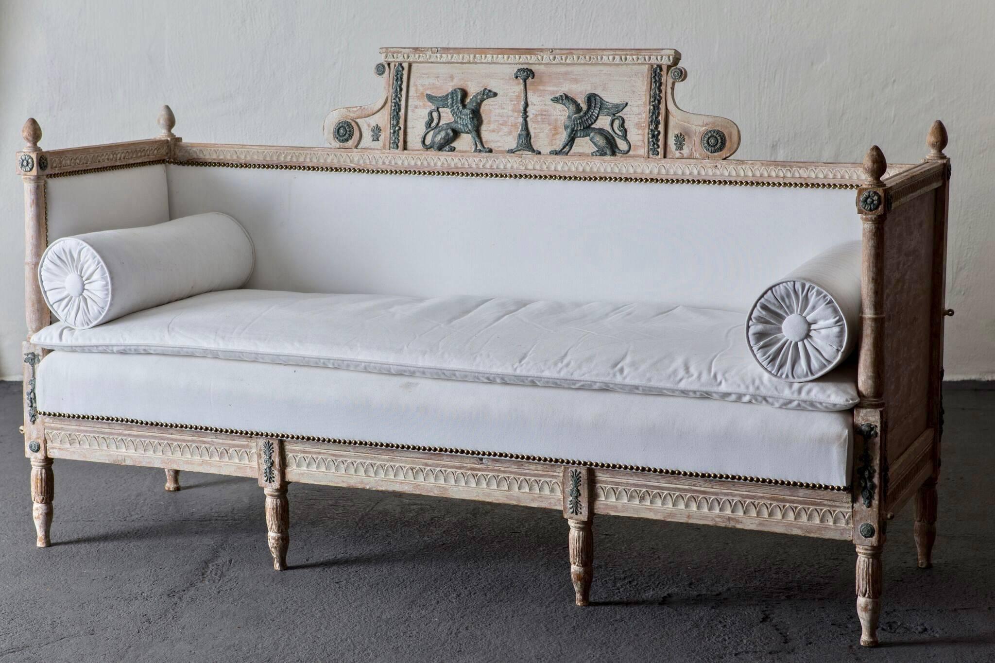 Sofa bench Swedish neoclassical 19th century, Sweden. Sofa made in Sweden during the period 1790-1810. Frame in birch in original white washed paint with green details such as sphinxes and laurel drops. Upholstered in a soft white cotton fabric with