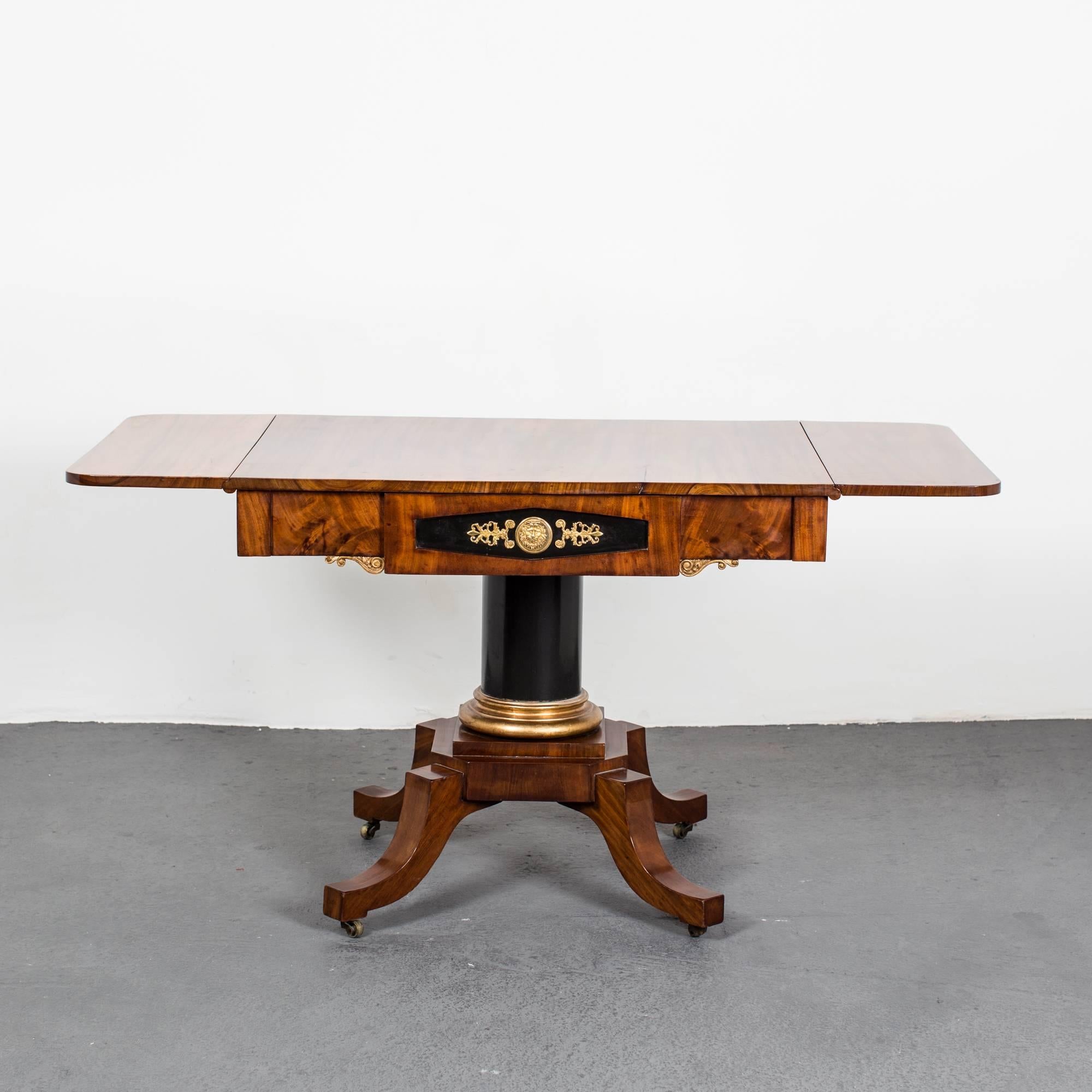 A drop-leaf table made during the Empire period, circa 1810 in Stockholm, Sweden. Exquisite quality. Drawer in frieze decorated with gilt bronze hardware in the shape of a lions head and palm leaves. Height from floor to apron 24.2 in.