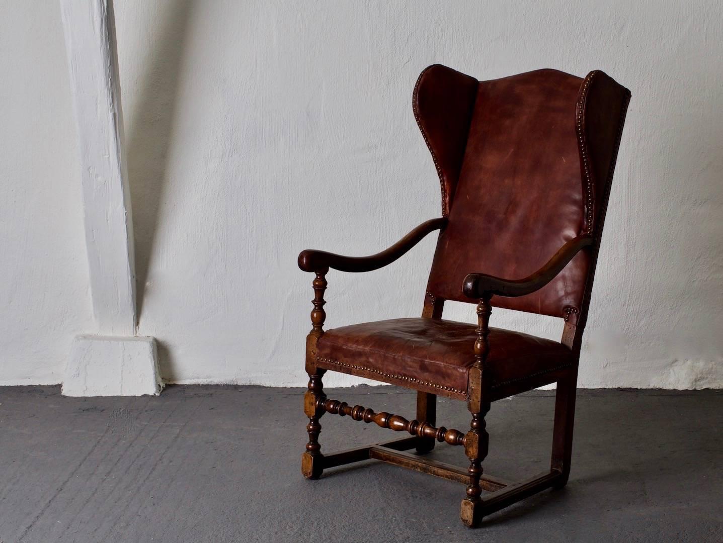 Chair Wingback Swedish Baroque Period Sweden. A wingback chair made during the Baroque period (1650-1750) in Sweden. A beautiful frame made from oak with an upholstered seat and back in a worn leather. Great patina and dark brown color. Height to