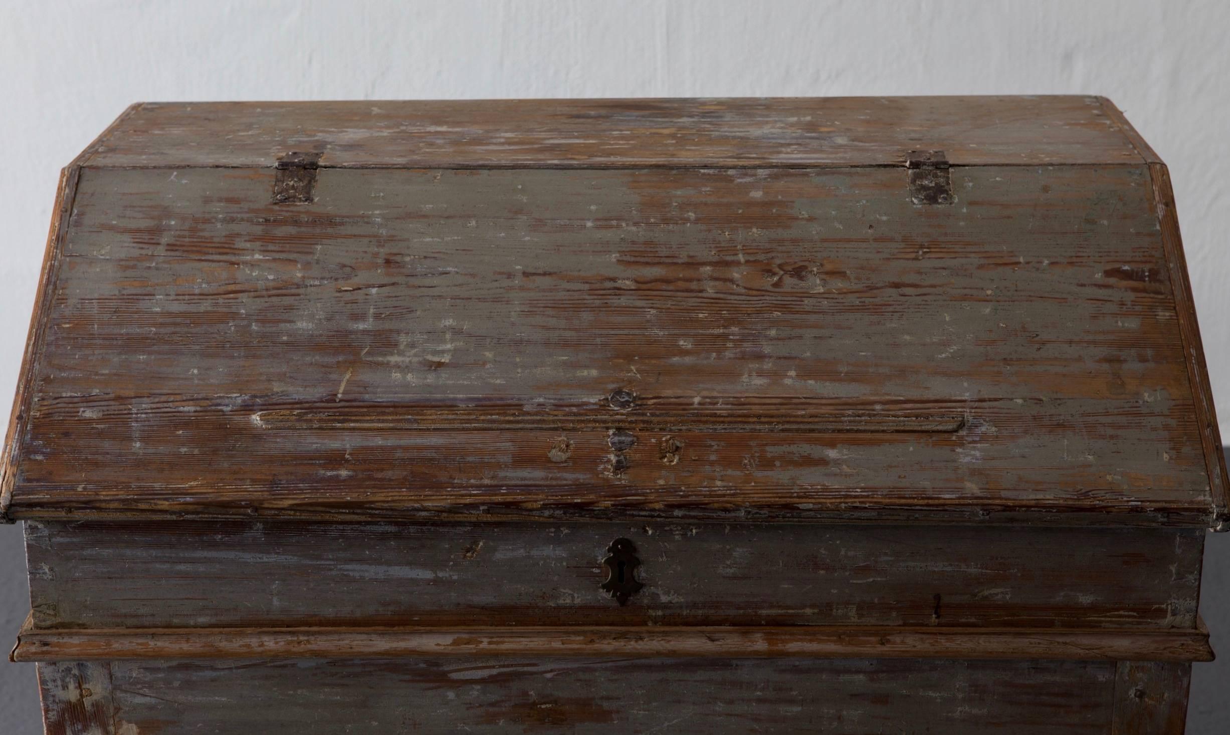 A Swedish writing desk made during the 18th century in Sweden. Original greyish green paint and hardware. Curved legs. Interior with drawers, shelves and compartments. 

          