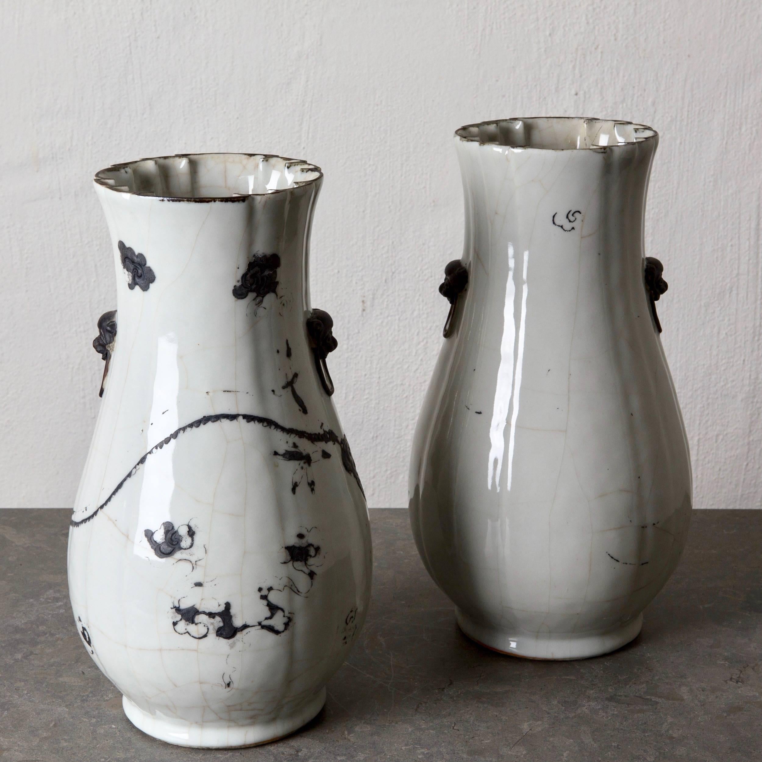 Ein Paar Vasen aus dem 19. Jahrhundert, die in Japan hergestellt wurden. Weißer Hintergrund mit schwarzen Details.