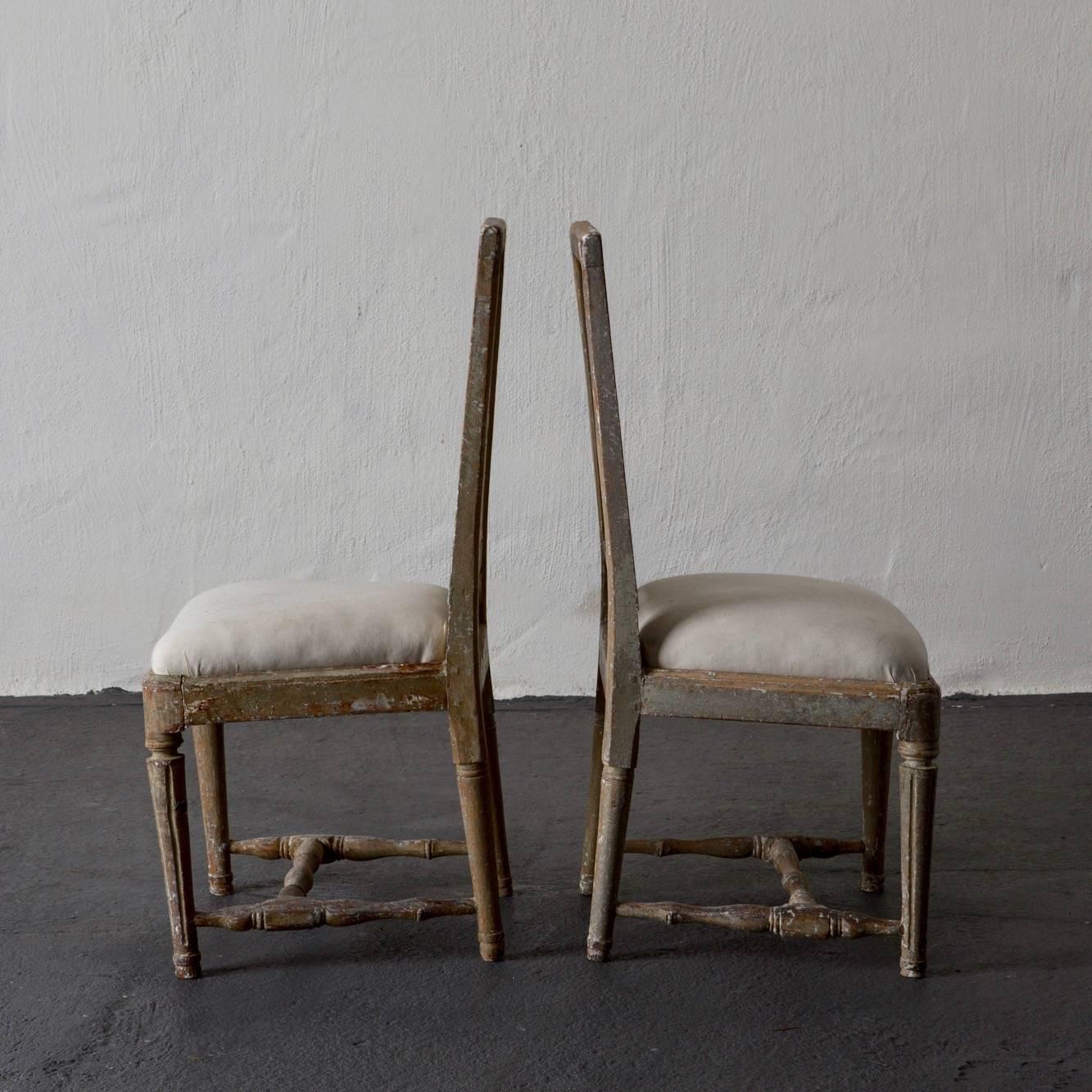 A set of four side chairs made during the Gustavian period in Sweden 1790-1810. The original paint in a grayish green which has a stunning patina. Rounded legs with channeled details. 