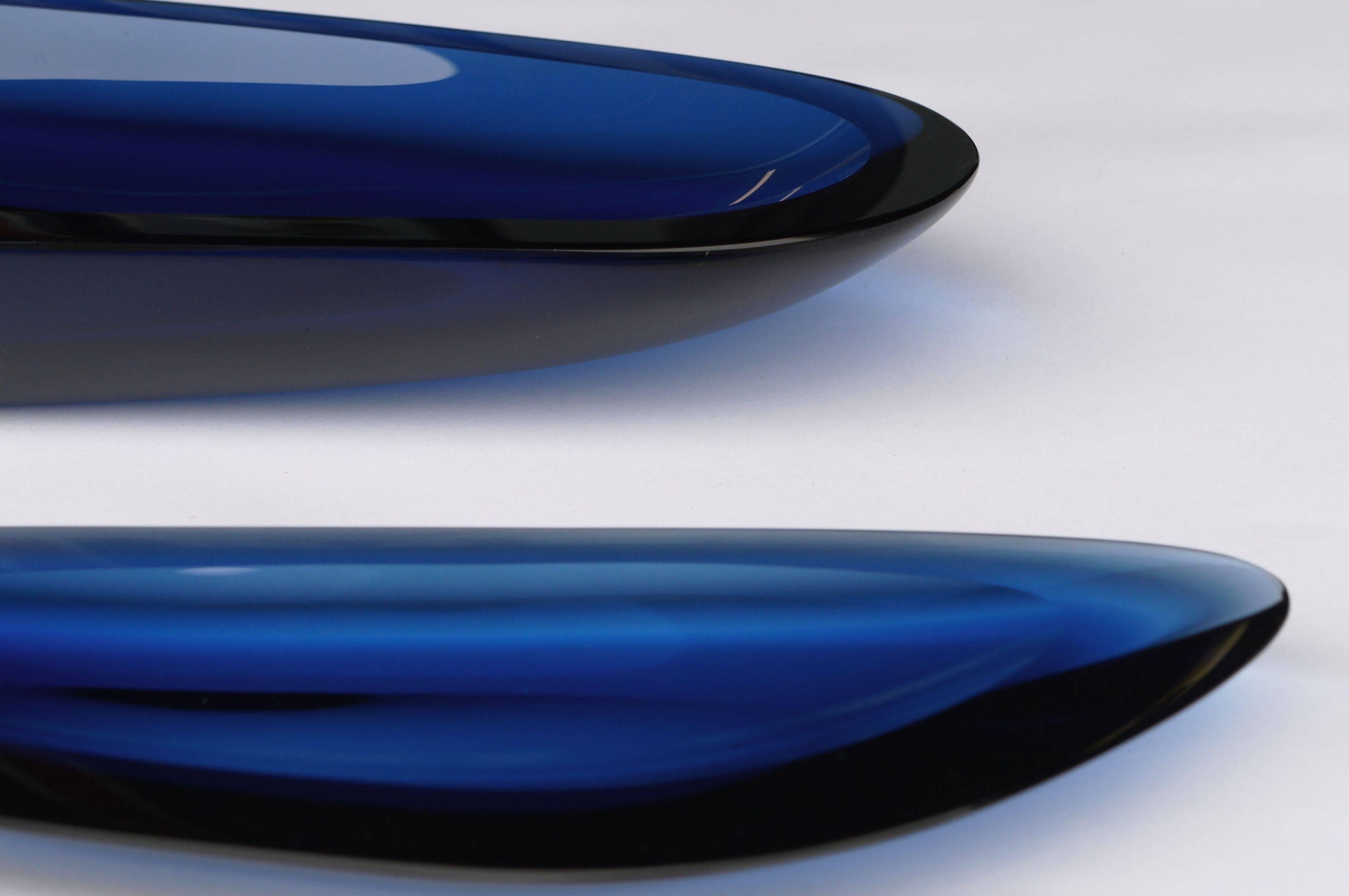 Stunning sleek hand-carved glass bowls by Ghiro Studio. Each piece is signed on underside. Larger bowl measures 15.5