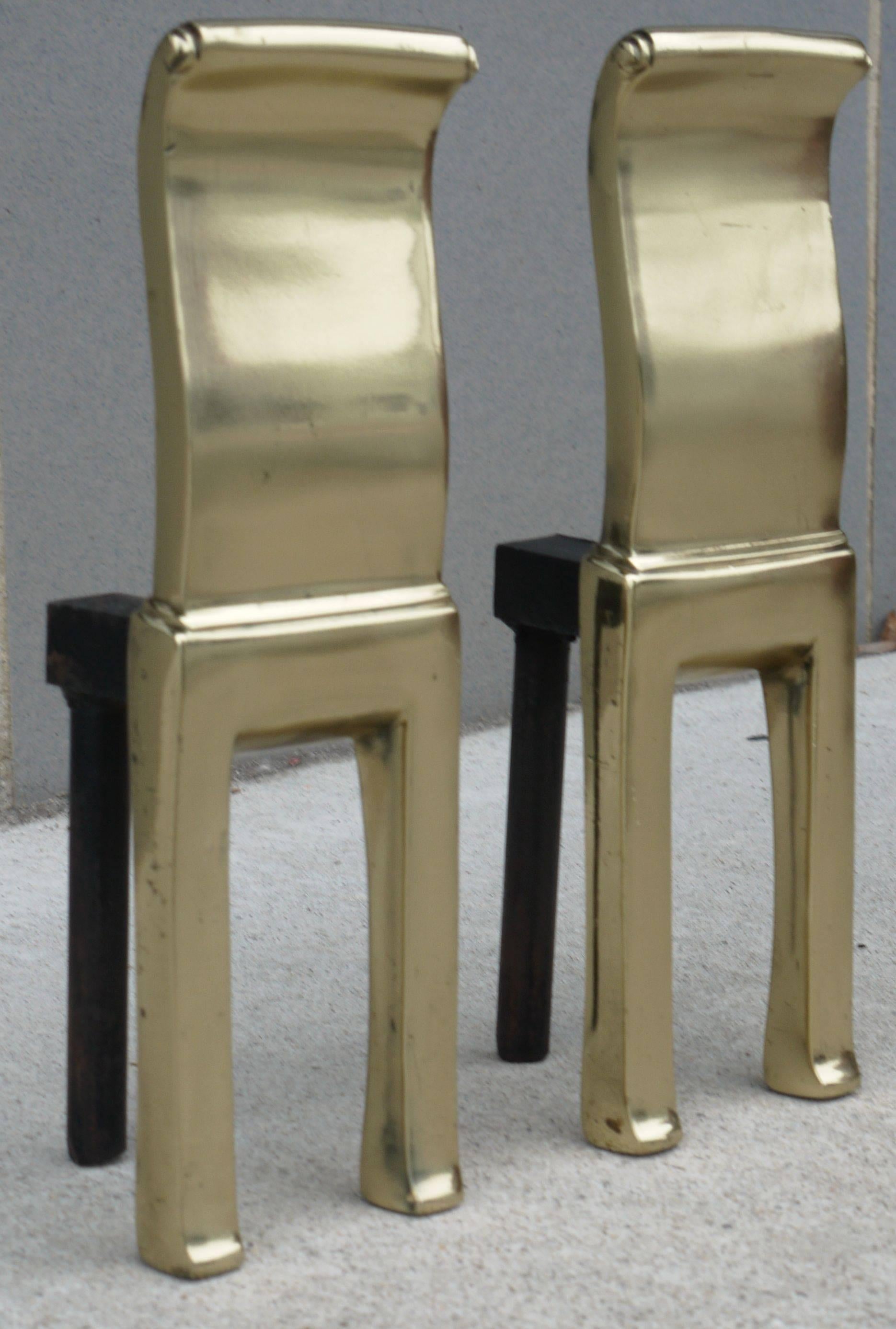 Pair of modernist brass andirons or firedogs with heavy cast iron stands by Virginia Metalcrafters. These have the shorter backs made for display or for use with a gas fireplace.