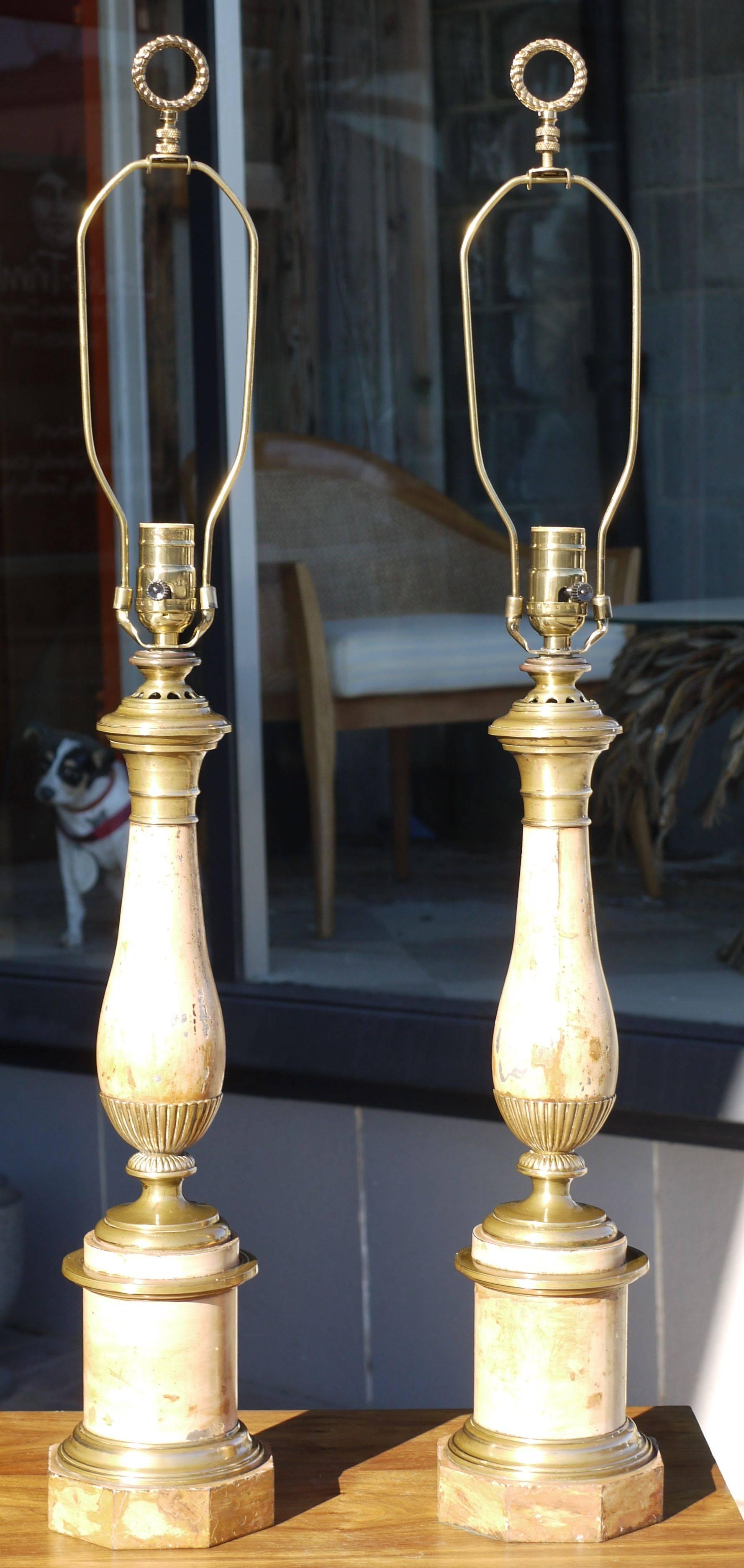 Stunning pair of French faux travertine tole and bronze lamps from the late 19th century they were converted from oil lamps at some point probably in the 1920s.  Measurements is to top of socket, shades not included.