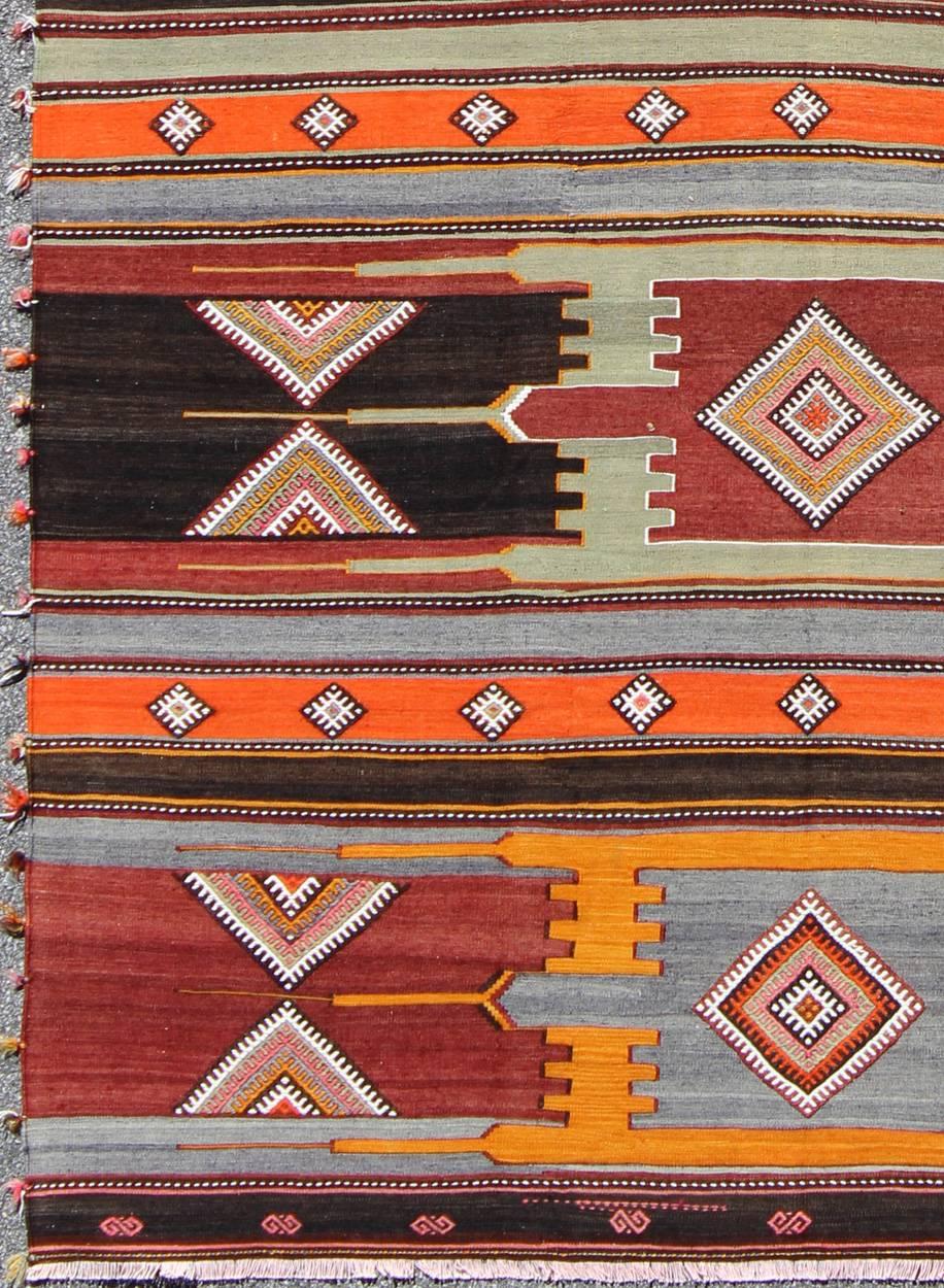 Fine Sivas Vintage Turkish Kilim, Large Turkish Kilim.
Featuring tribal shapes with a spotted and speckled assortment of geometric elements, this unique Mid-Century Kilim showcases an array of rich colorful tones that have been softened by age. A