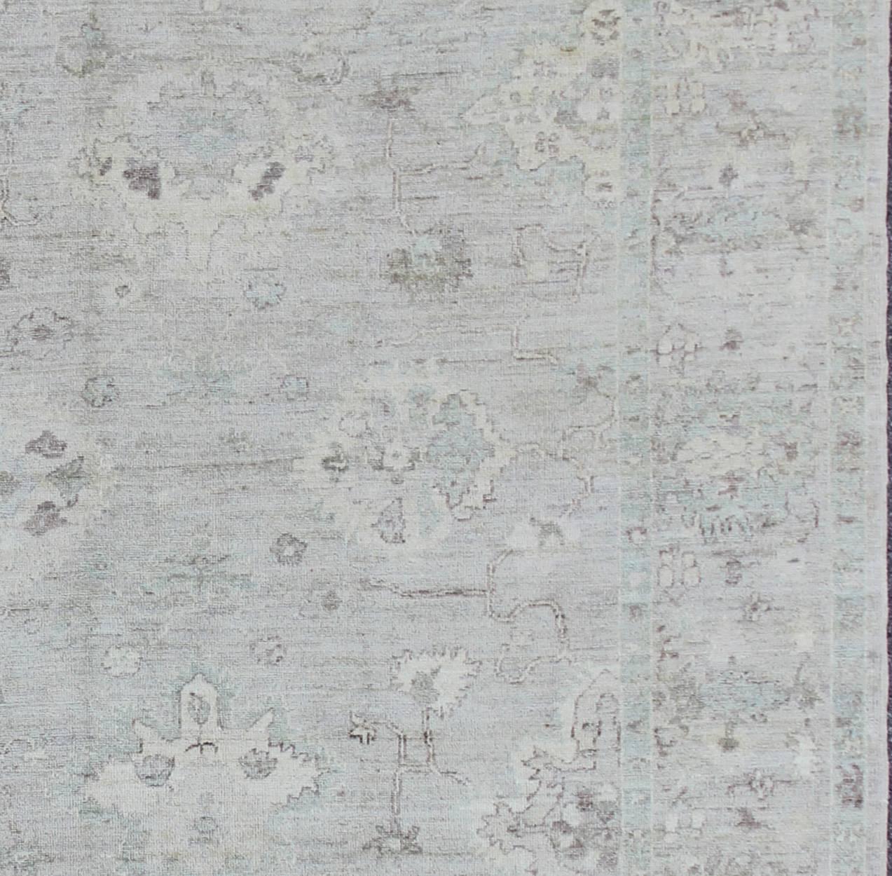 Made with a combination of angora and old wool, this magnificent Oushak boasts an all-over design in a large-scale style. The plentiful floral and bouquet motifs create an open design which is surrounded by a border containing defined and geometric