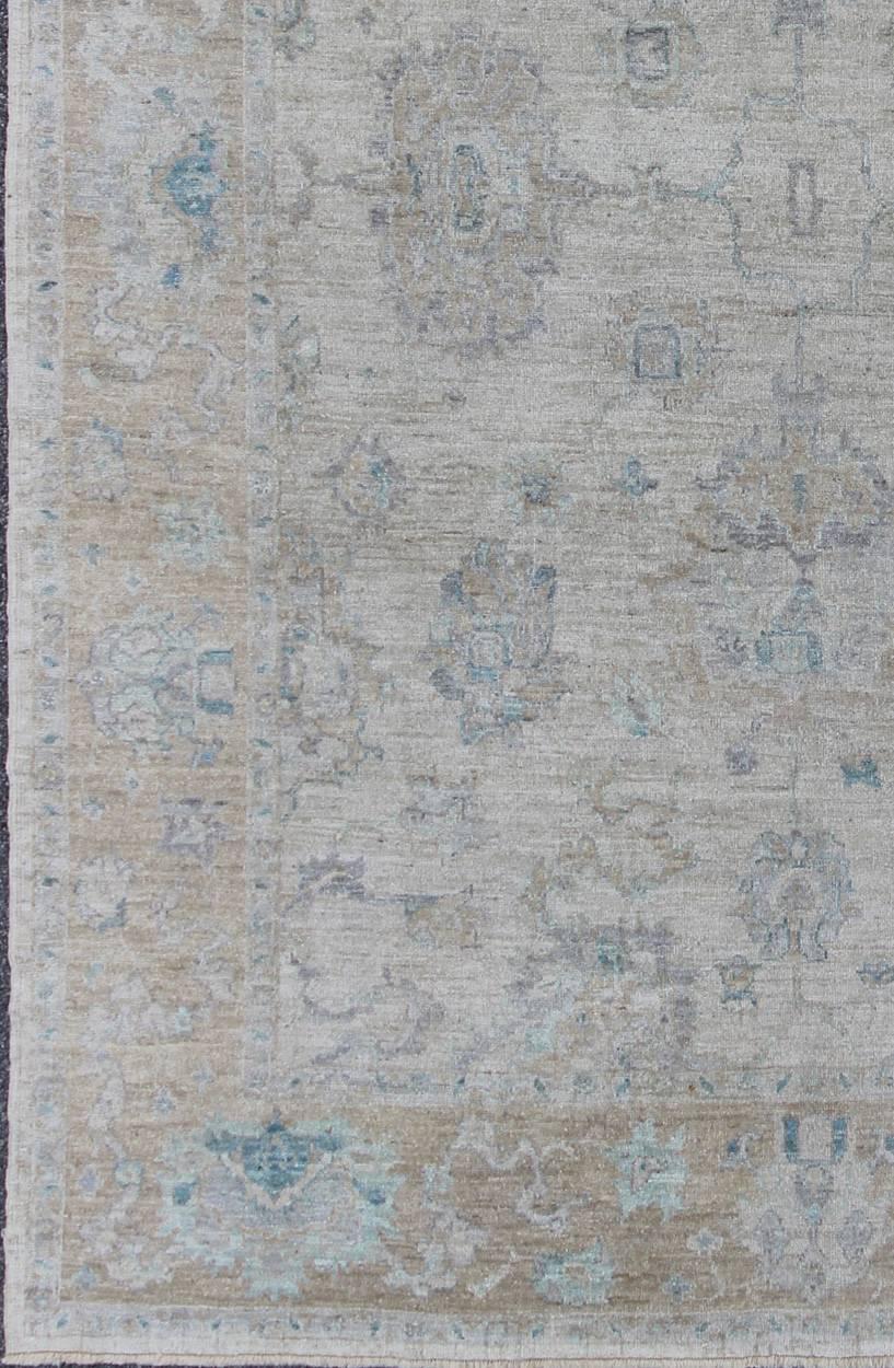 Made with a combination of angora and old wool, this magnificent Oushak boasts an all-over design in a large-scale style. The plentiful floral and bouquet motifs creates an open design which is surrounded by a border containing defined and geometric