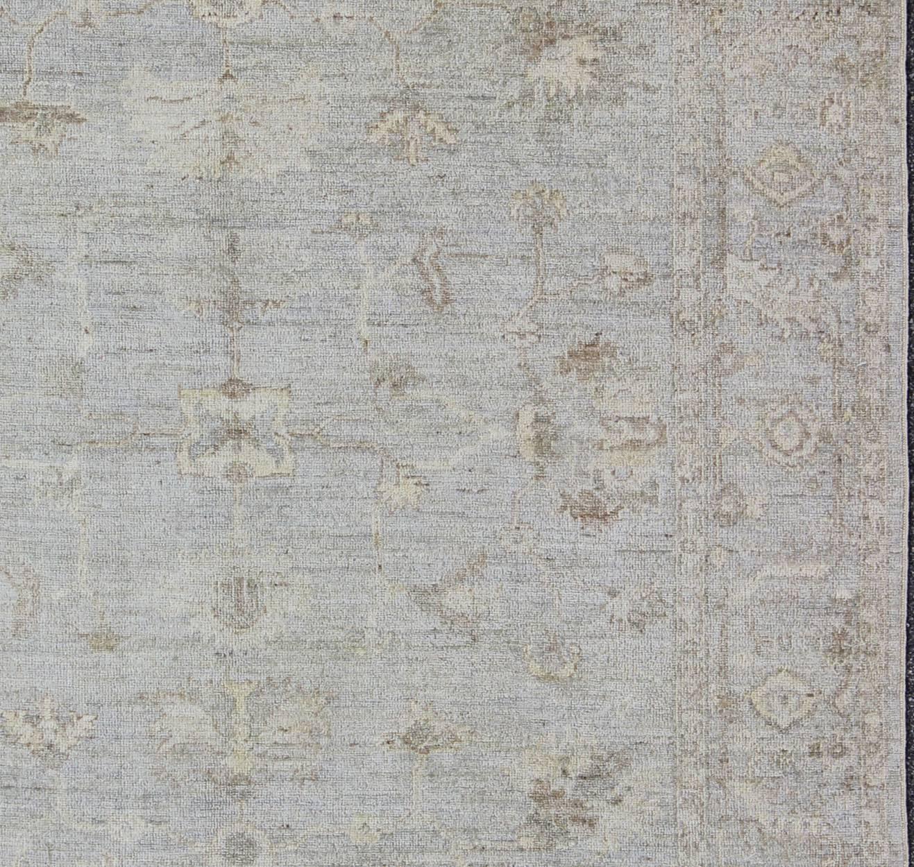 Made with a combination of angora and old wool, this magnificent Oushak boasts an all-over design in a large-scale style. The plentiful floral and bouquet motifs creates an open design which is surrounded by a border containing defined and geometric