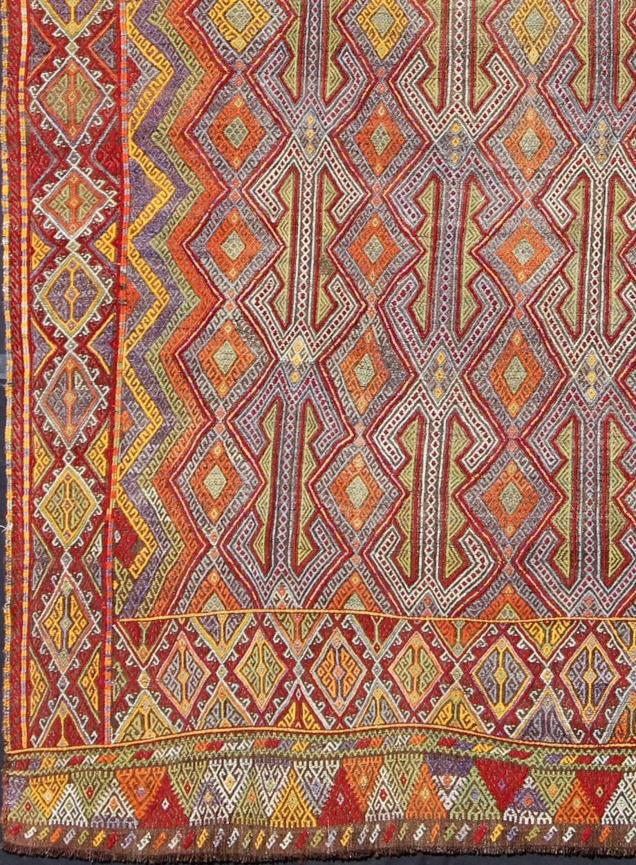 Large Vintage Turkish Embroidered Kilim in Bright and Colorful Tones                        

Measures: 7'4'' x 10'11''.
Featuring tribal shapes with a spotted and speckled assortment of geometric elements, this unique Jajeem / Jejim showcases an