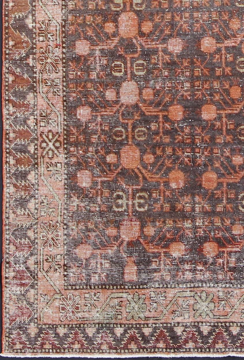 Antique Khotan Carpet in Charcoal, Burnt Red, Salmon and Taupe.
An antique, early 20th century, Central Asian Khotan rug with traditional all-over pomegranate pattern on a charcoal field surrounded by multiple complementary floral borders.