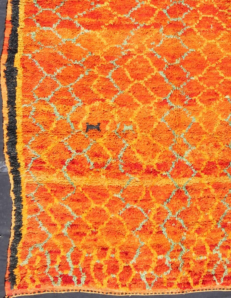 This rug was created in a deep tangerine, using pure hand spun wool, and features gentle colorful meandering lattice motifs with a strikingly creative use of color and balance. The thick charcoal lines function as a frame on each side of the rug.