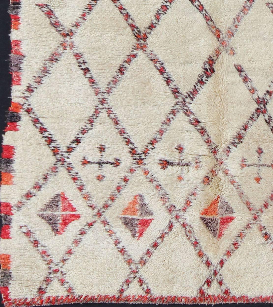 Mesures : 6'5'' x 11'7''.
Tissé en laine légère, crémeuse et filée à la main, avec des symboles rouges, gris et anthracite clair, ce magnifique tapis marocain présente un motif de grille sophistiqué à base de losanges qui englobe la totalité du