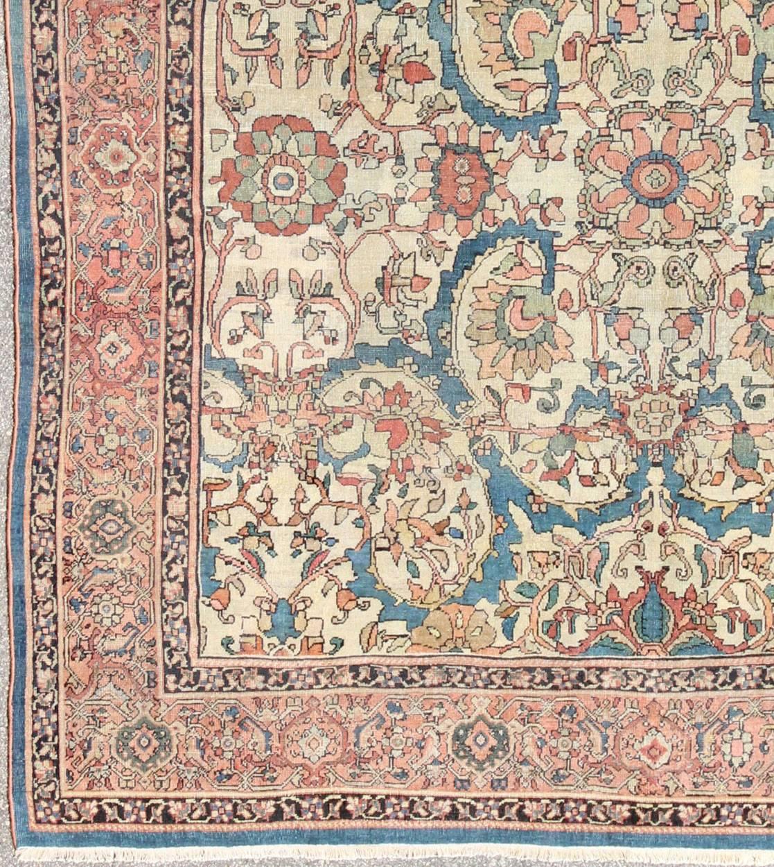 Tapis persan antique Sultanabad en fond ivoire, bleu, saumon et couleurs multiples.
Cet ancien tapis Sultanabad présente un motif à grande échelle composé de palmettes et de fleurs stylisées. Cette superbe pièce se caractérise par une combinaison de