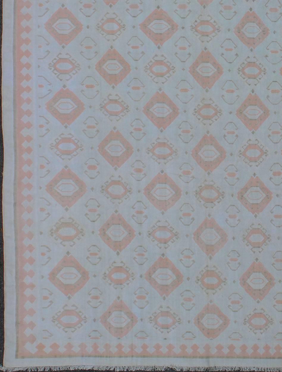 Dieser Mitte des 20. Jahrhunderts gewebte Dhurrie aus flachgewebter indischer Baumwolle ist mit einem Rautenmuster verziert und weist eine originelle, kontrastarme Farbpalette auf. Die sich wiederholenden geometrischen Motive zeichnen sich durch