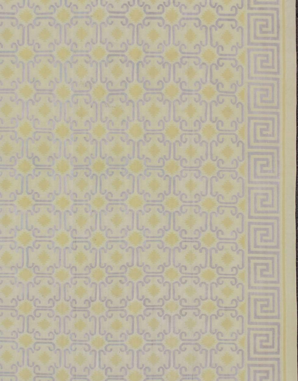 Woven during the mid-20th Century, this designer flat-woven Indian cotton dhurrie is adorned with east Turkestan/Khotan motifs and features an inventive low-contrast color palette. A Greek key border frames the entire background, while repeating