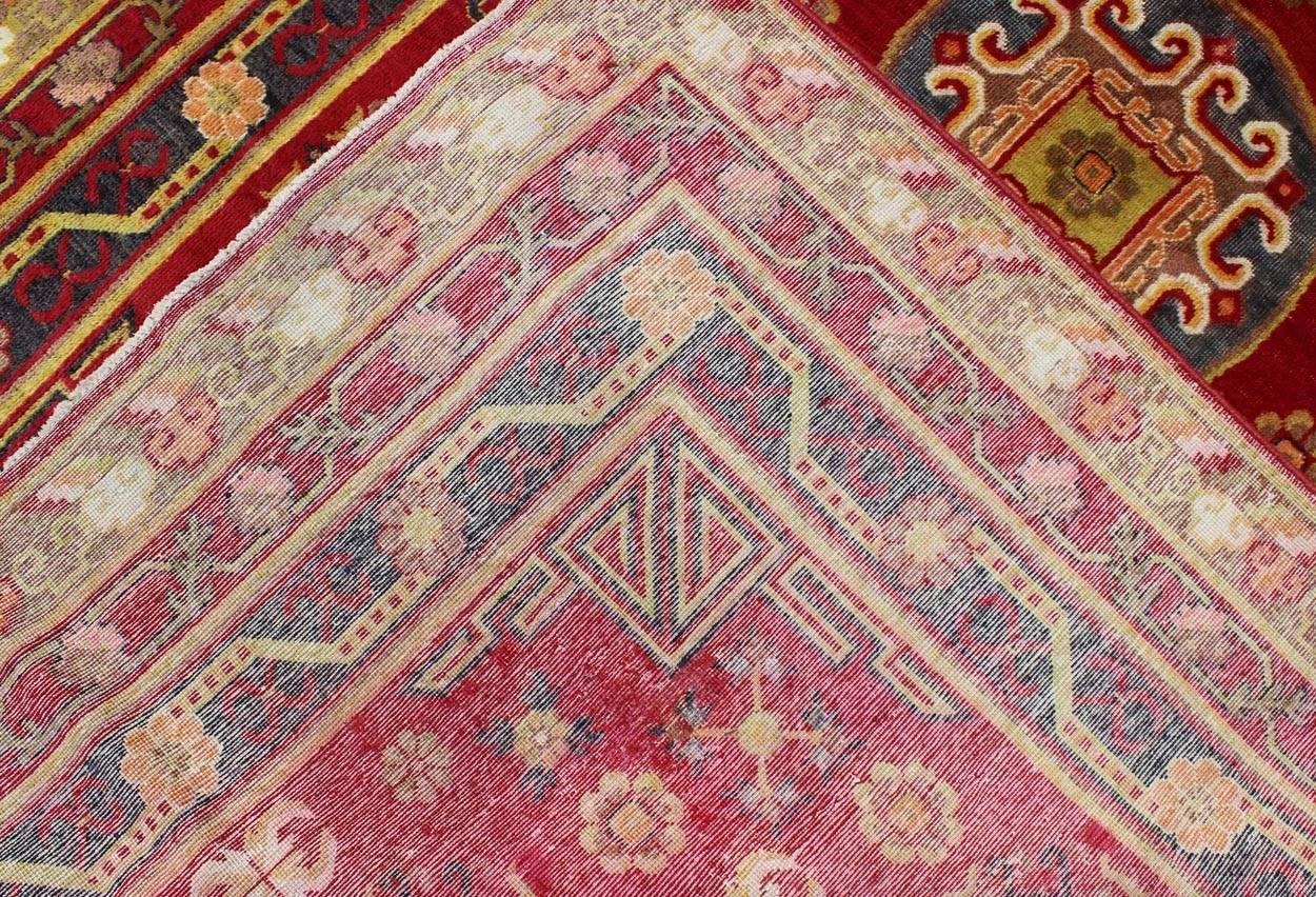 Early 20th Century Antique Khotan Rug in Rich Red, Green and Charcoal Colors For Sale