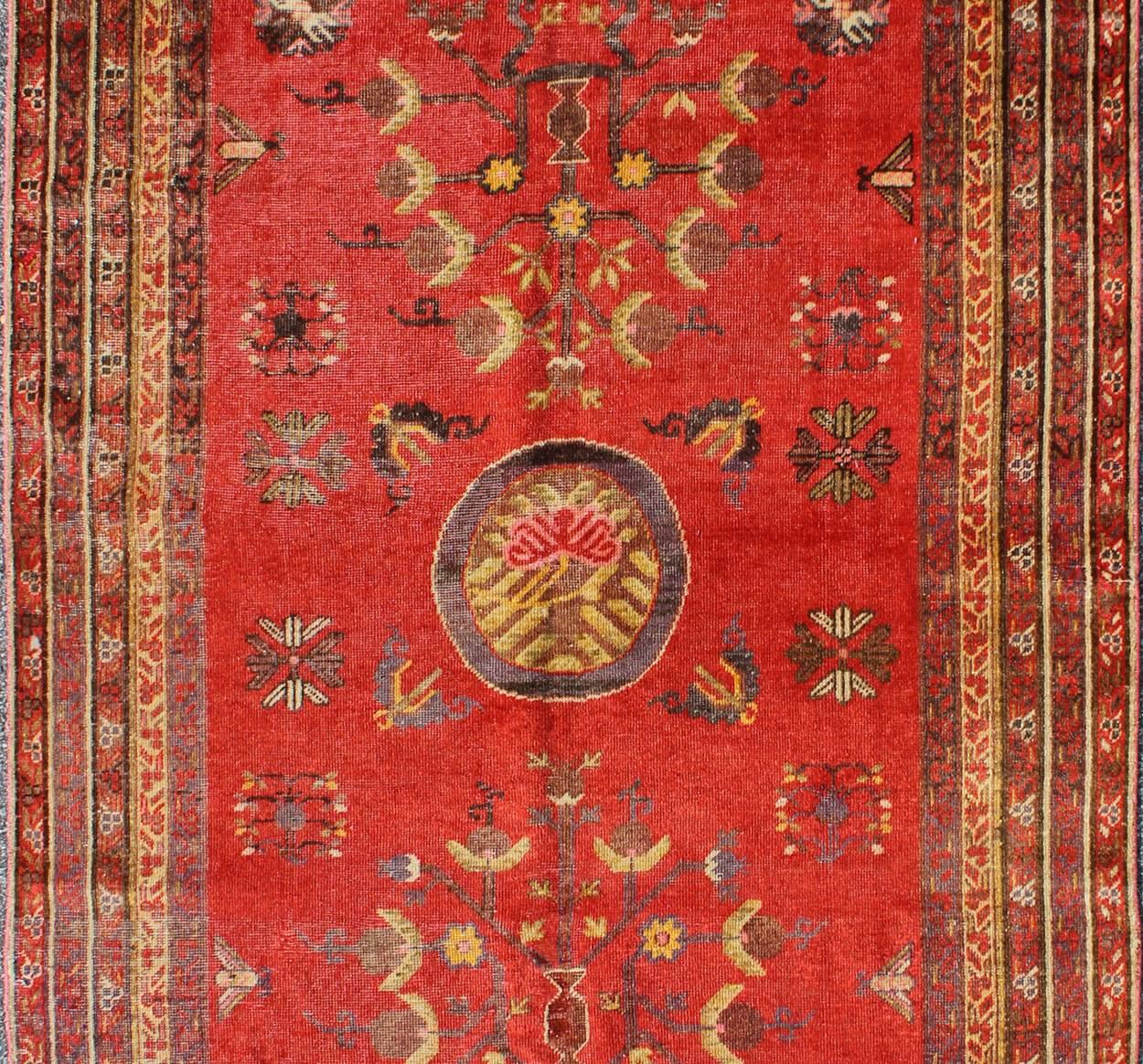 Turkestan oriental Tapis Khotan rouge vif avec motif floral sous-géométrique sur toute sa surface en vente