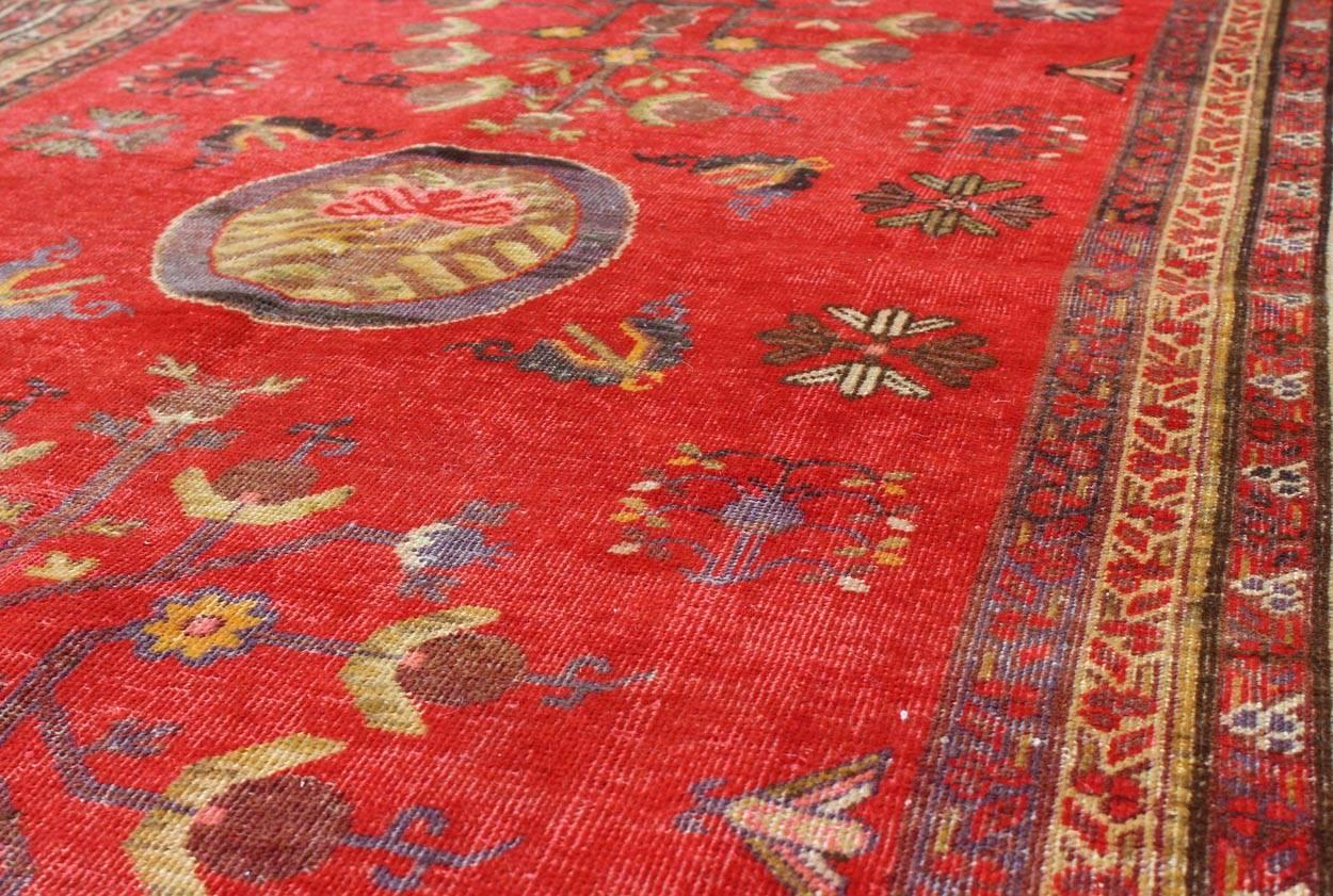 20ième siècle Tapis Khotan rouge vif avec motif floral sous-géométrique sur toute sa surface en vente