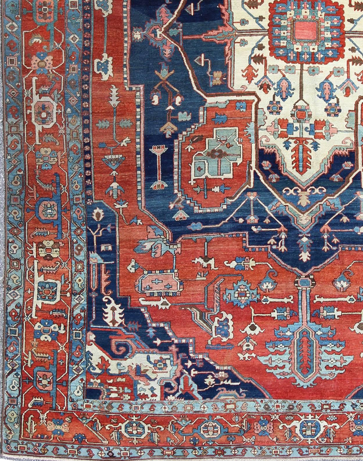 Antique Persian fine weave Serapi rug with large geometric medallion in brilliant colors and blue and tomato red. Keivan Woven Arts / Rug / N15-1204 / country of origin / type: Iran /Serapi, circa 1900. 
Measures: 10.3 x 14.4.
Antique Serapi rugs