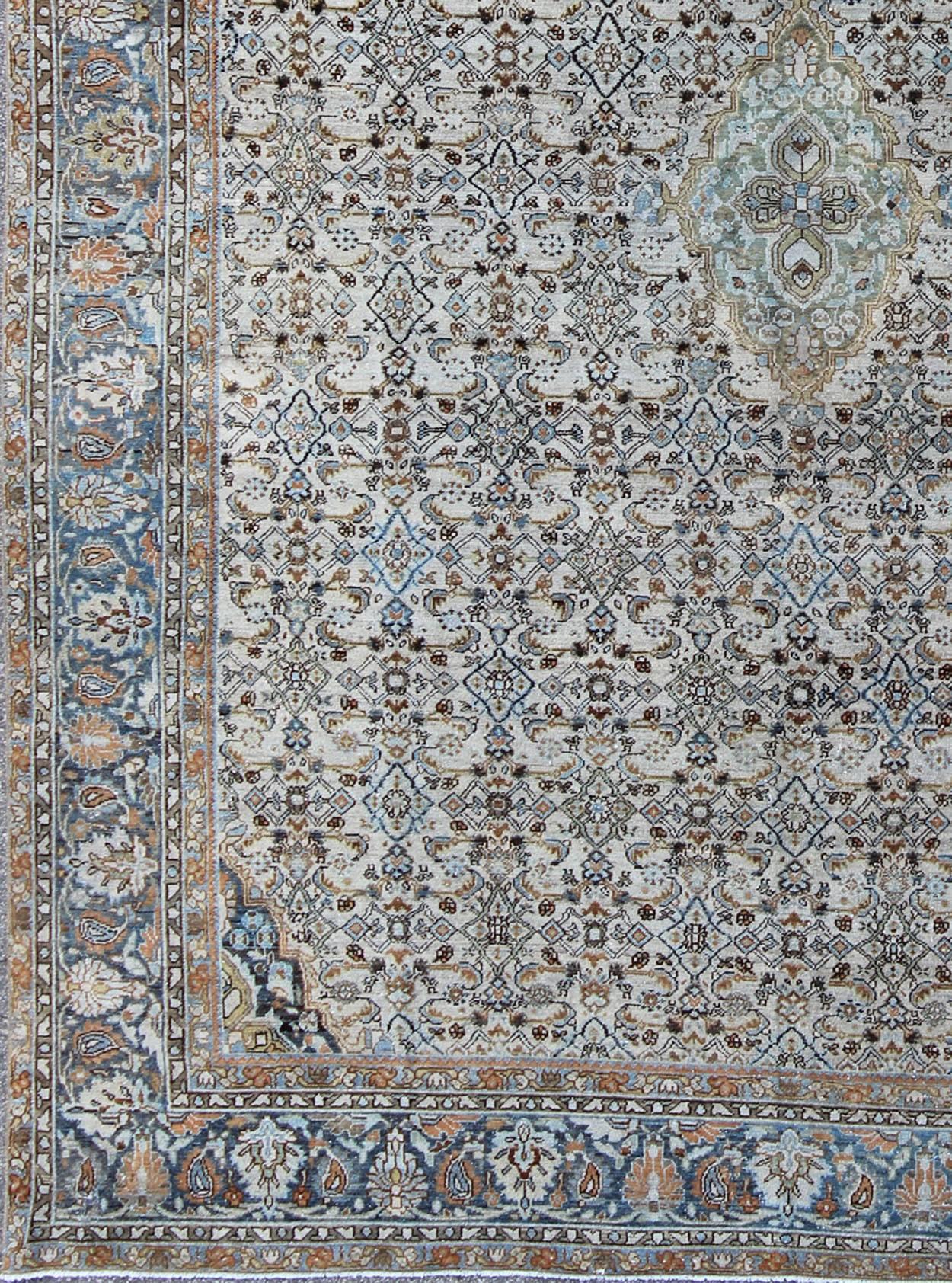 Antique Persian Malayer unique rug in steel blue border and ivory background. Rug/NA-160298.
This magnificent antique Persian Malayer carpet, of an impressive size, bears a beautiful, all-over Sub-geometric design paired with a delightful palette of