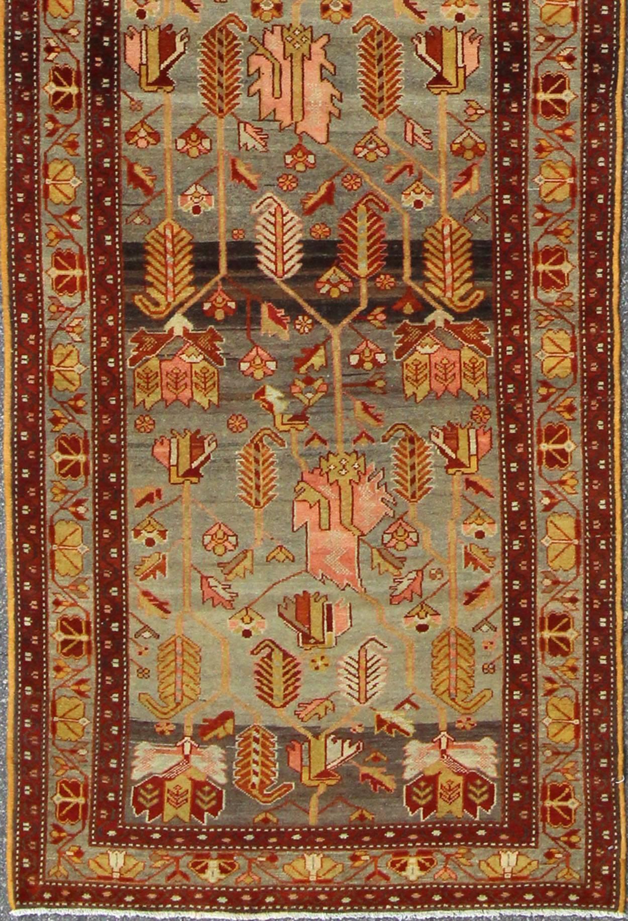 This magnificent antique Persian Malayer carpet, of an impressive pattern, bears a beautiful, all-over sub-geometric design paired with a delightful palette of dark reds, various blues, pinks, yellow-green, brown and a very light green. The central