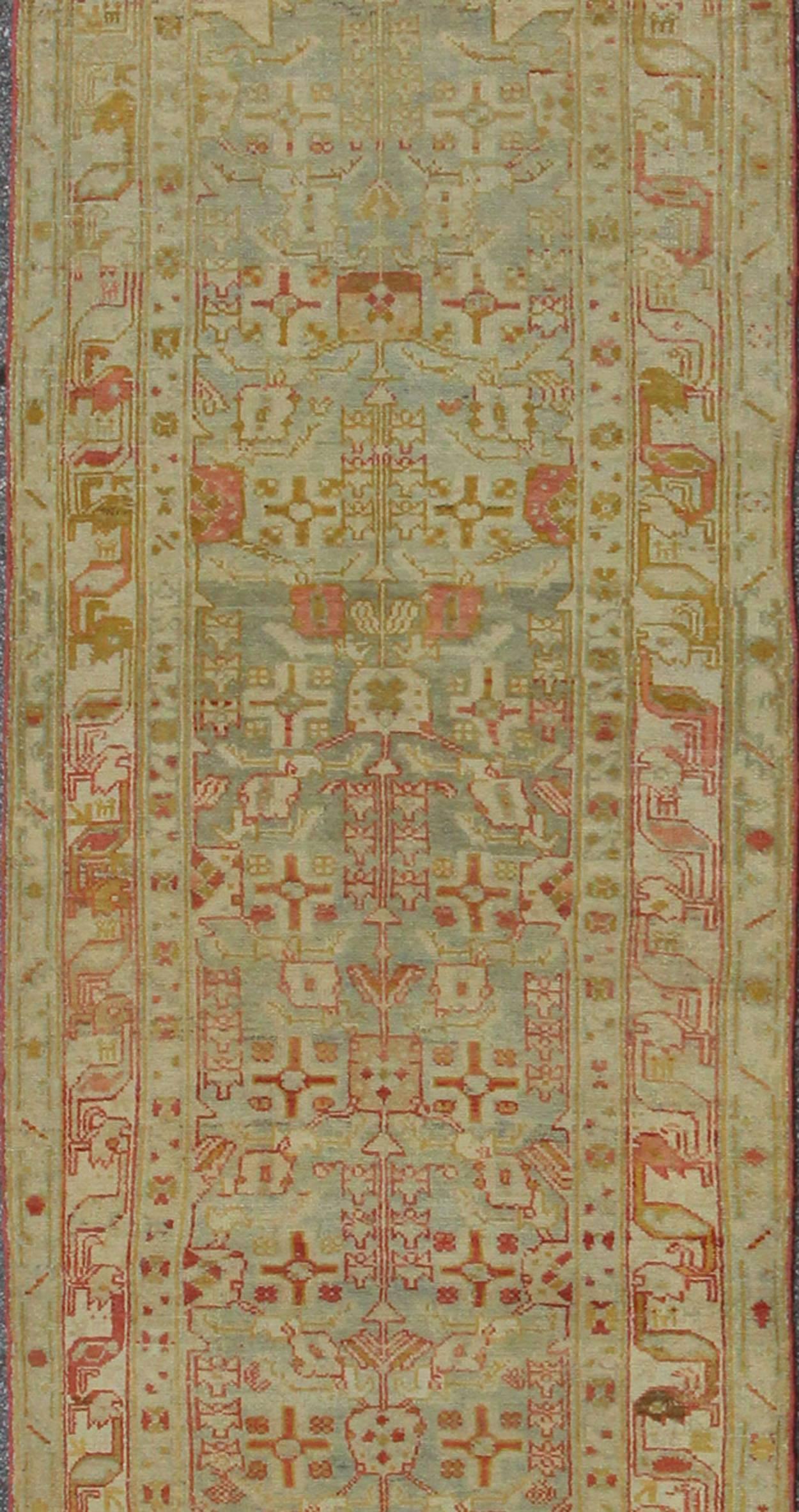 This magnificent antique Persian Malayer carpet of an impressive pattern bears a beautiful, all-over sub-geometric design paired with a delightful palette of coral, various blues and a very light peach. The central field is filled with a dazzling