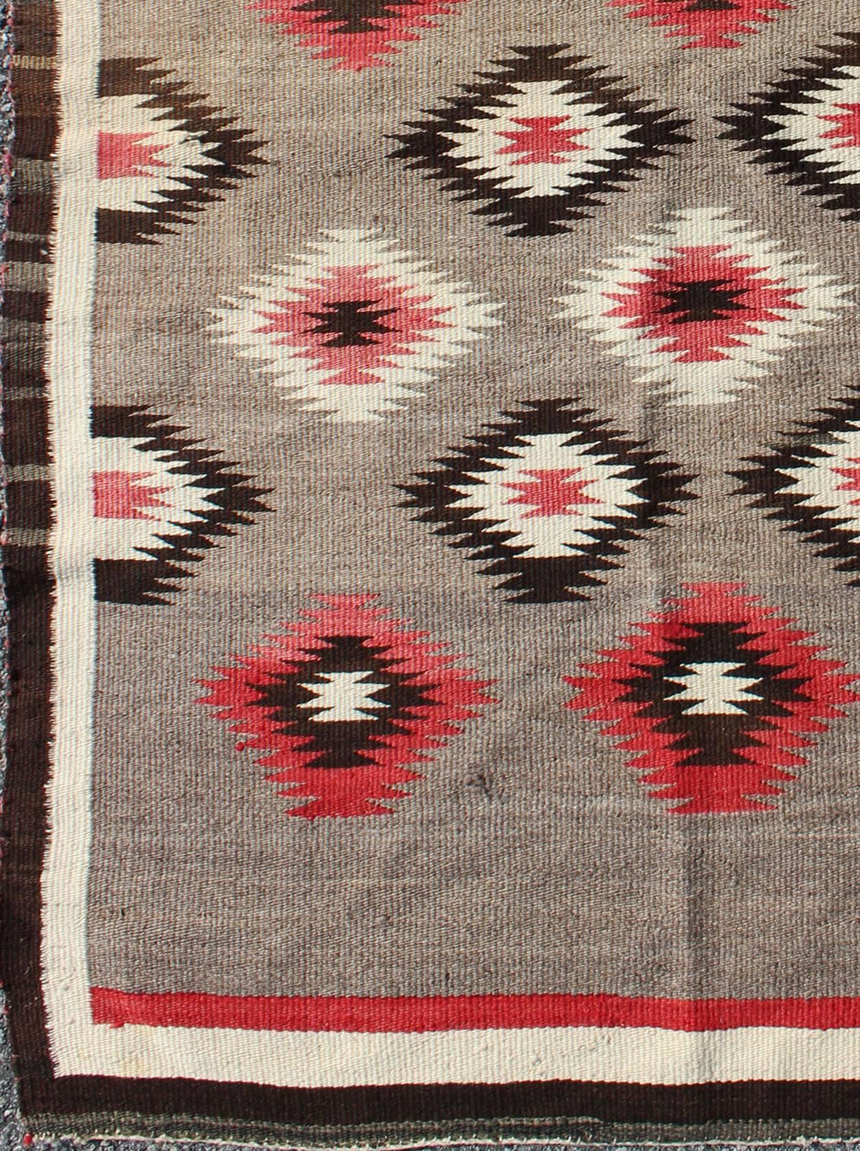 Measures: 3'0'' x 4'10''.
This intriguing vintage Navajo rug was woven in the United States during the first half of the 20th century. The exciting and unique composition boasts a captivating geometric composition with an all-over diamond design.