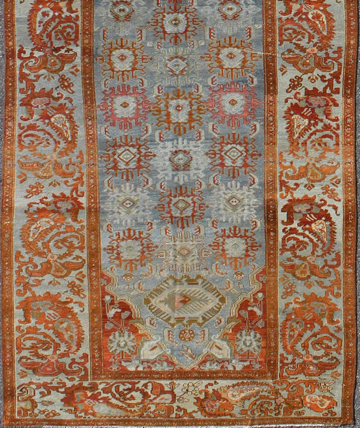 This magnificent antique Persian Malayer carpet, of an impressive size, bears a beautiful, all-over Sub-geometric design paired with a delightful palette of burnt orange, various blues and a very light peach. The central field is filled with a
