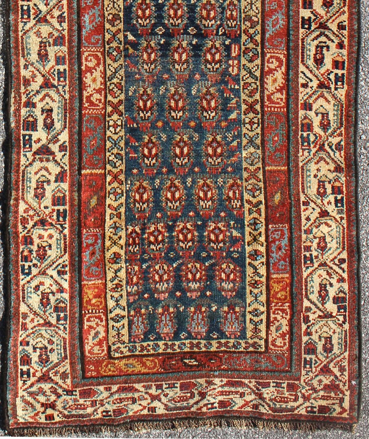 This antique runner was woven in far northwest Persia in the area bordering the Caucasus. The vibrant color and saturation of its finely drawn elements are enhanced by their placement against a deep indigo field. The main border is composed of