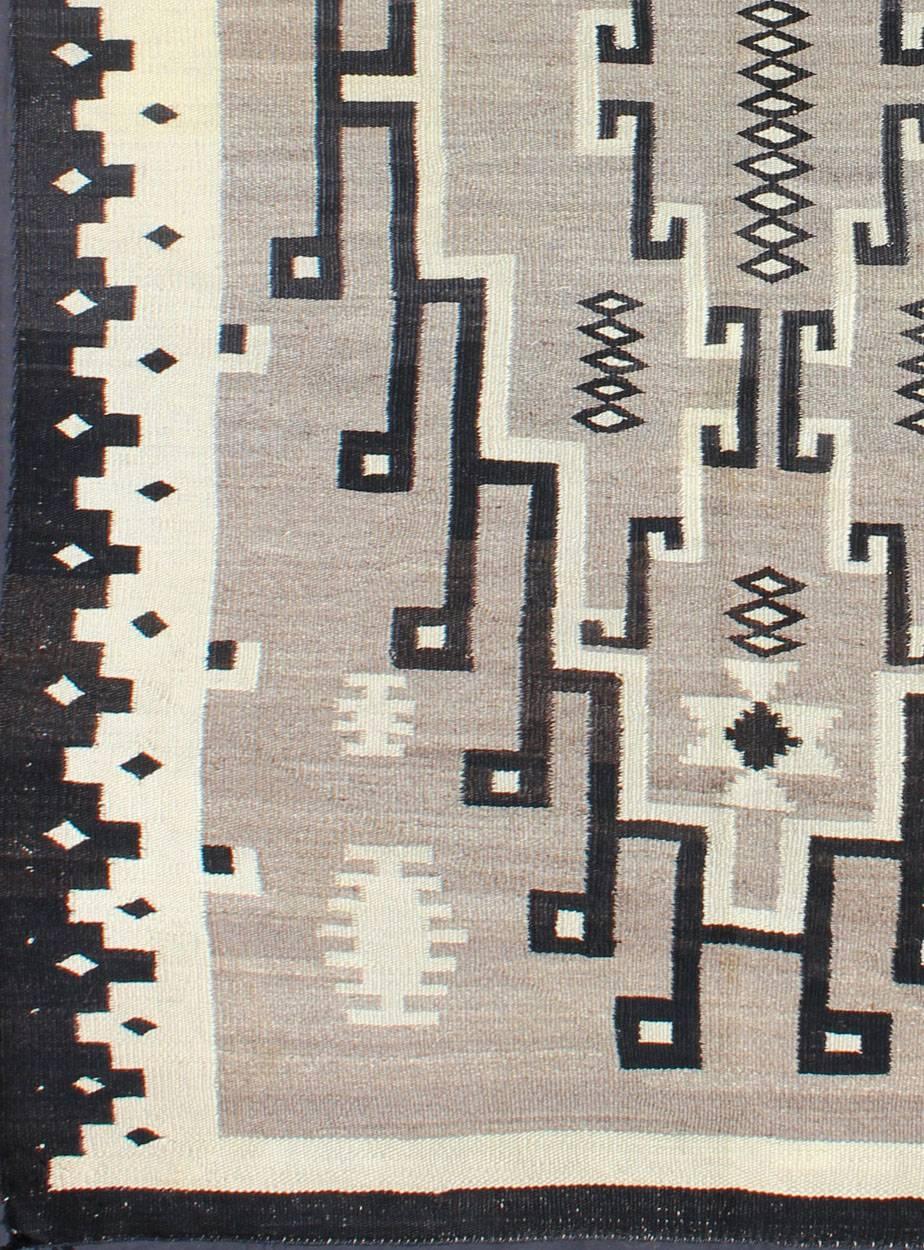 This intriguing Navajo rug was woven in the United States during the first half of the 20th century. The exciting and unique composition boasts a captivating geometric composition with an all-over medallion design. The range of colors includes