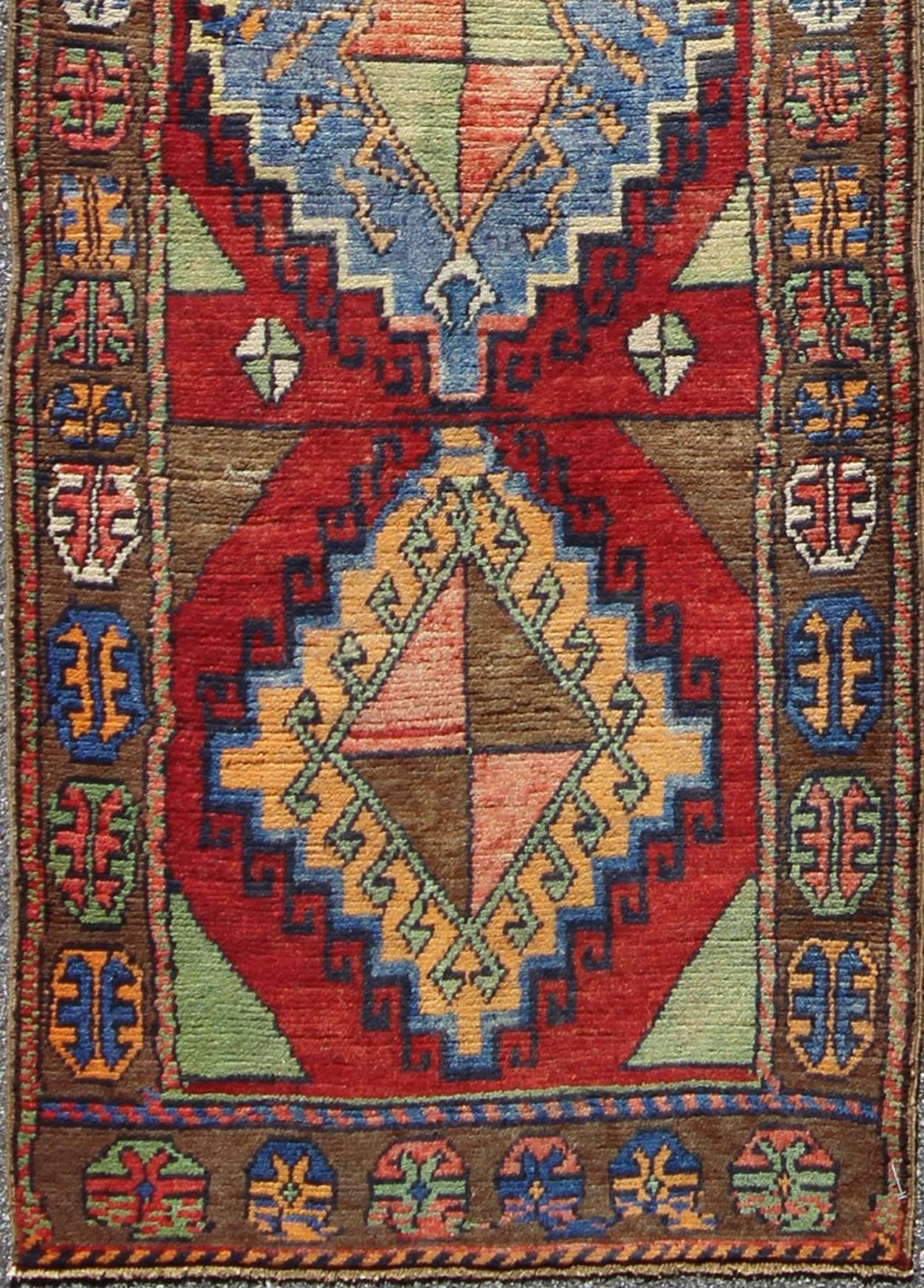 Hand knotted vintage Turkish Oushak Runner with Geometric Tribal design, Keivan Woven Arts / TU-VEY-4608, mid-20th century. Turkish oushak vintage Runner.

This vintage Turkish Oushak runner features four medallions vertically arranged in the red