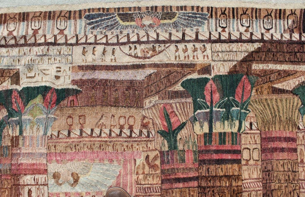 Rare Vintage Tapestry with Exquisite Scene of Egyptian Architecture and Columns. 16-1005
This exquisite tapestry from the late 20th century is composed of handwoven wool and features a richly colorful architectural Scene. A lone figure stands among