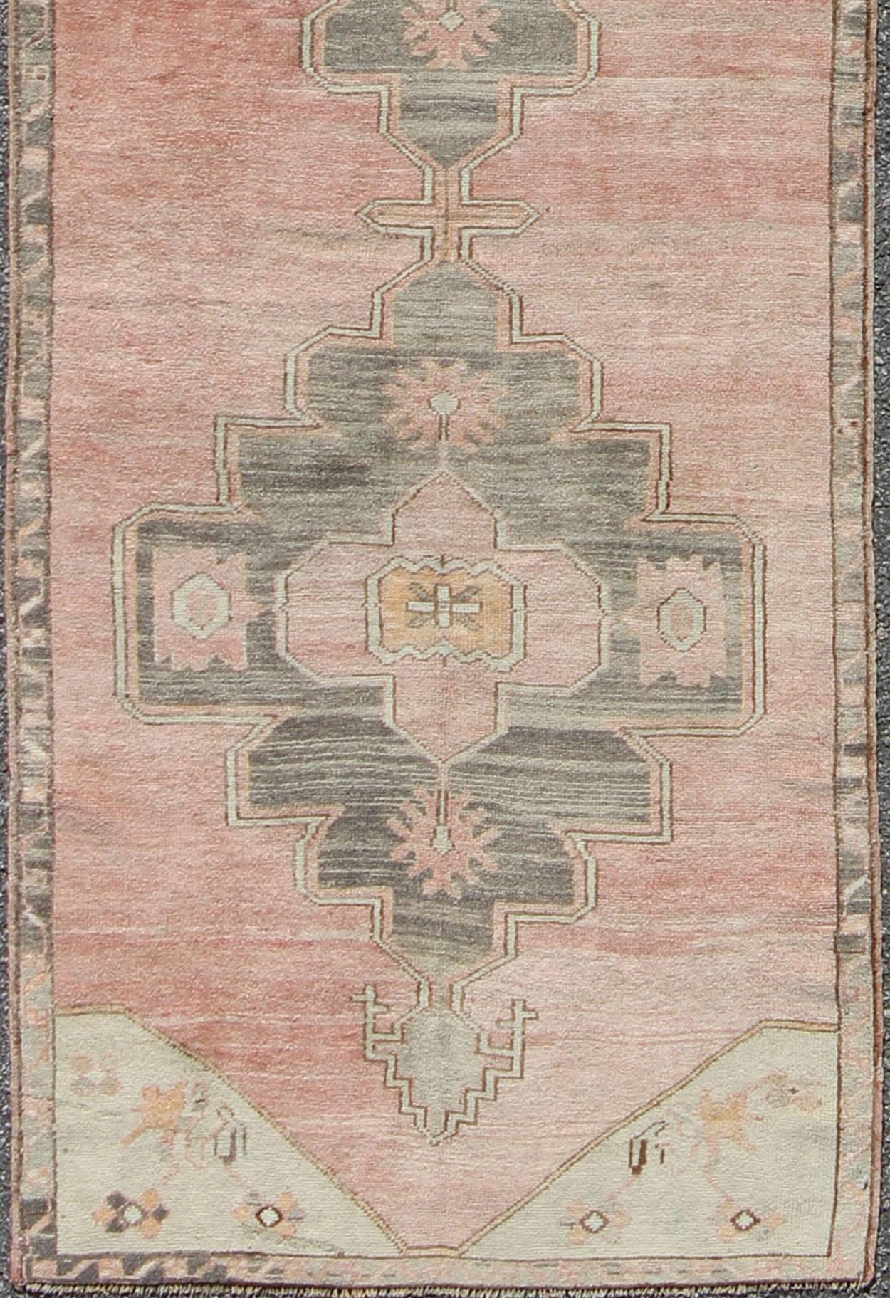 Misure: 3'0'' x 11'4''.
Questo delizioso Oushak presenta tre medaglioni centrali in grigio chiaro con un campo centrale corallo, caratterizzato da fiori e motivi a traliccio. Il bordo corallino dai toni tenui ripete ed espande il motivo dei