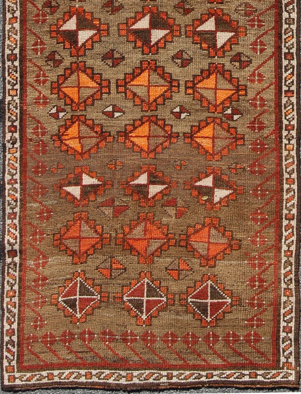 Antique Turkish Tribal Runner in green background and rusty red, orange/ Keivan Woven Arts rug/TU-TRS-4645. Turkish antique runner

This colorful Oushak runner contains tones of rust red, coral, taupe, orange, gray, beige, and brown. The stylized