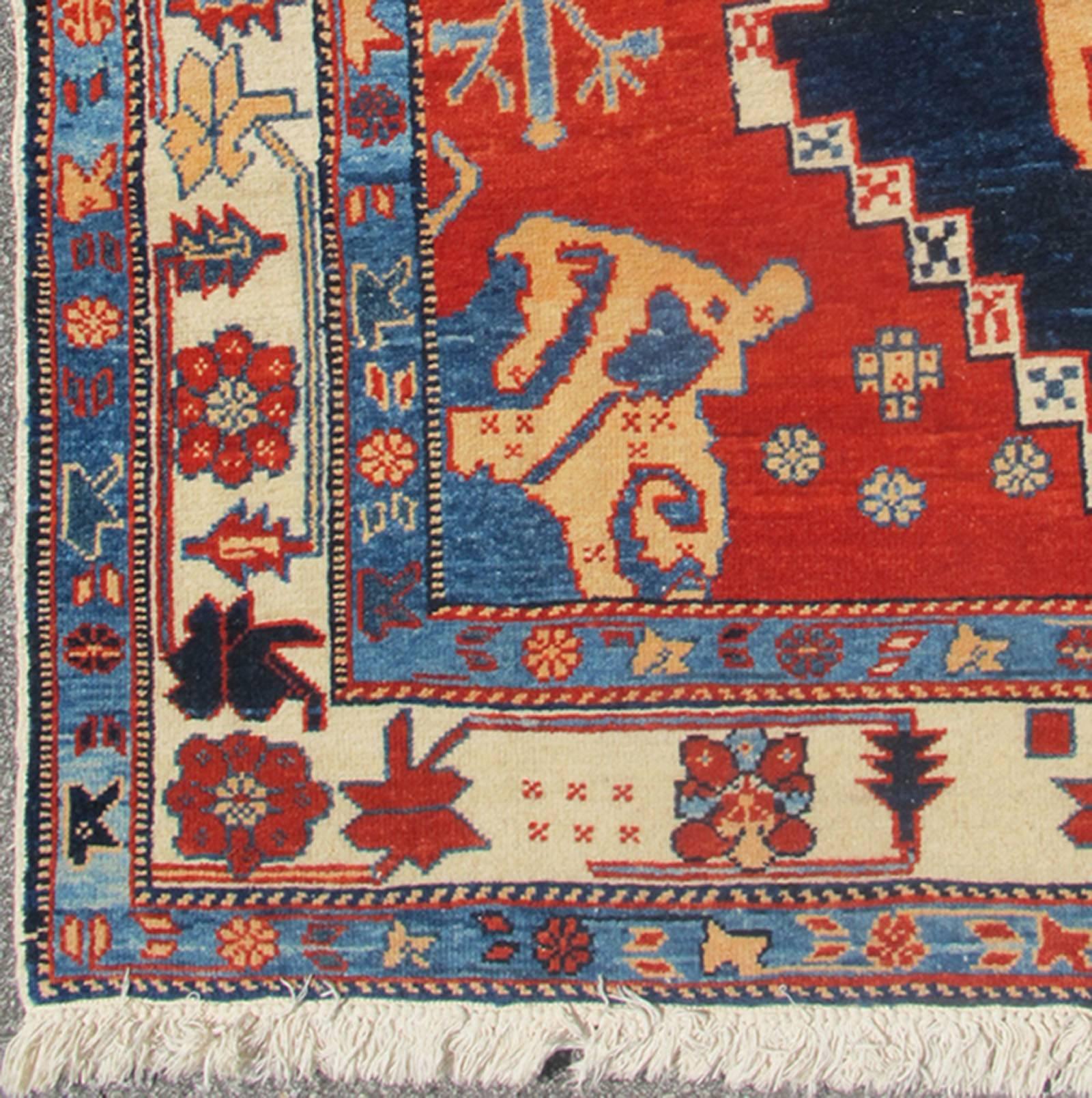 Vintage Turkish Tribal Rug with Jewel-Toned Central Medallion and Vivid Colors, Rug/ dsp-wl30362.  This vintage Turkish Tribal rug features a large central medallion and a jewel-toned geometric design surrounded by a vivid blue and ivory