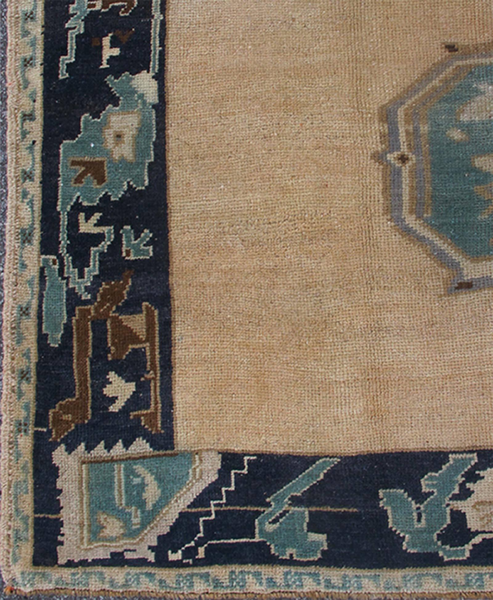 This beautiful vintage Oushak runner from mid-20th Century Turkey features a Classic Oushak design, which is enhanced by its lustrous wool. The faint coral ground is home to two large and elegant medallions of taupe, teal and various blue tones.