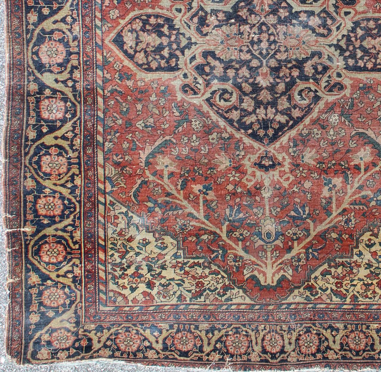 This outstanding antique Farahan Sarouk carpet is primarily characterized by its classical composition. This beautiful carpet represents the highest levels of mastery achieved by Persian weavers. It showcases floral elements and vine scrolls that