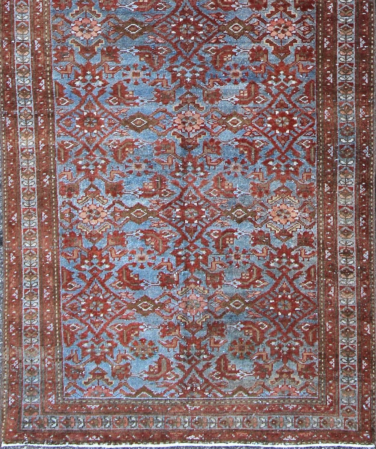 This magnificent antique Persian Malayer carpet, of an impressive size, bears a beautiful, all-over sub-geometric design paired with a delightful palette of various shades of light blue, deep red and taupe. The central field is filled with a