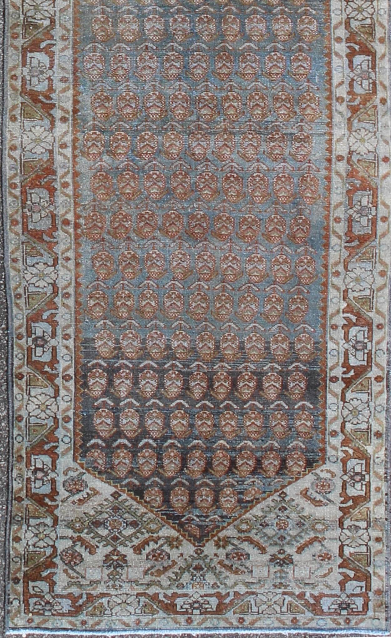 This magnificent antique long Persian Malayer runner, of an impressive size, bears a beautiful, all-over sub-geometric design paired with a delightful palette of various shades of blue, ivory, sea foam green, and rust. The central field is filled