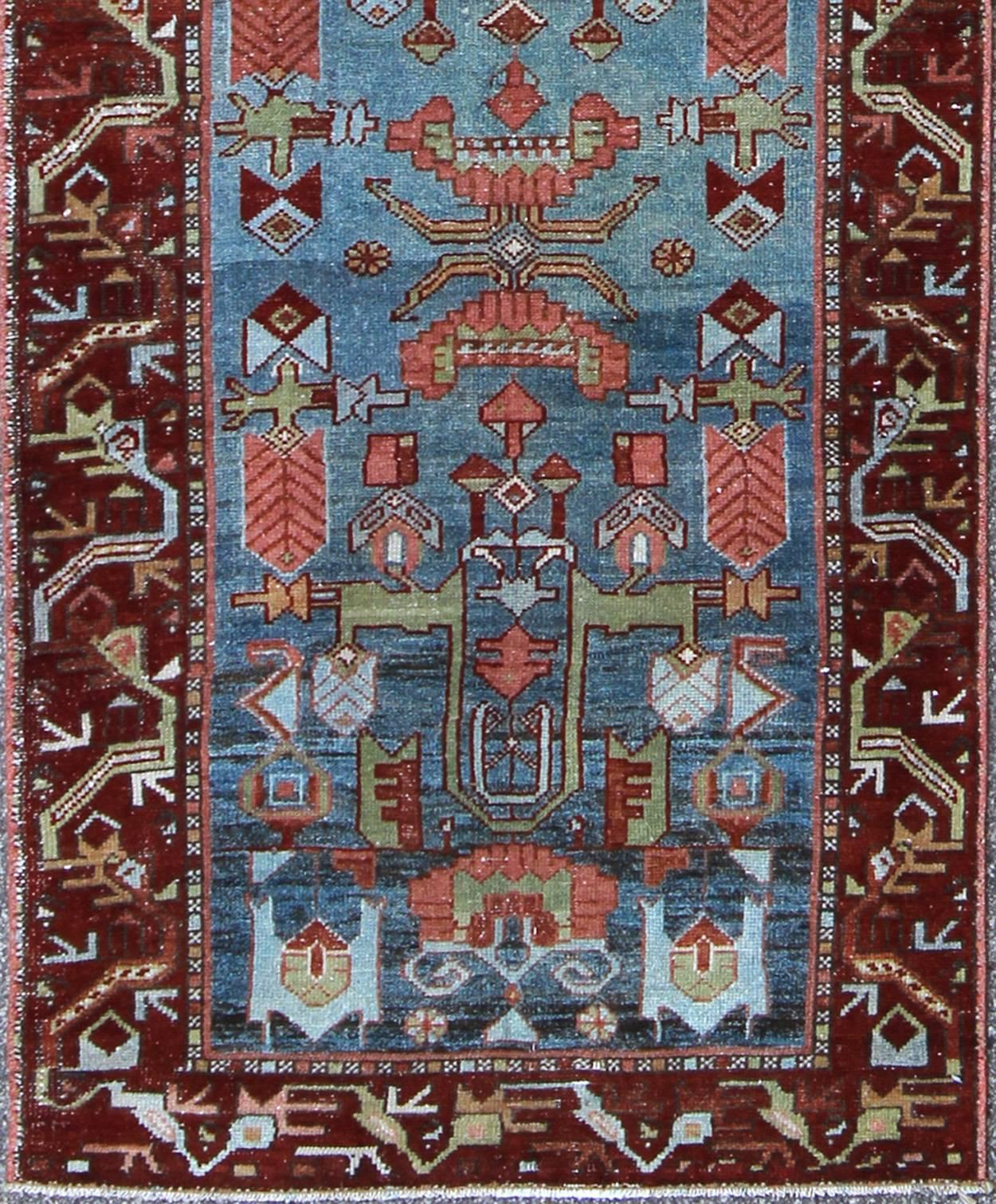 This magnificent antique Persian Malayer runner, of an impressive size, bears a beautiful, all-over sub geometric design paired with a delightful palette of various shades of medium blue, deep red, rust, light blue, and green. The central field is