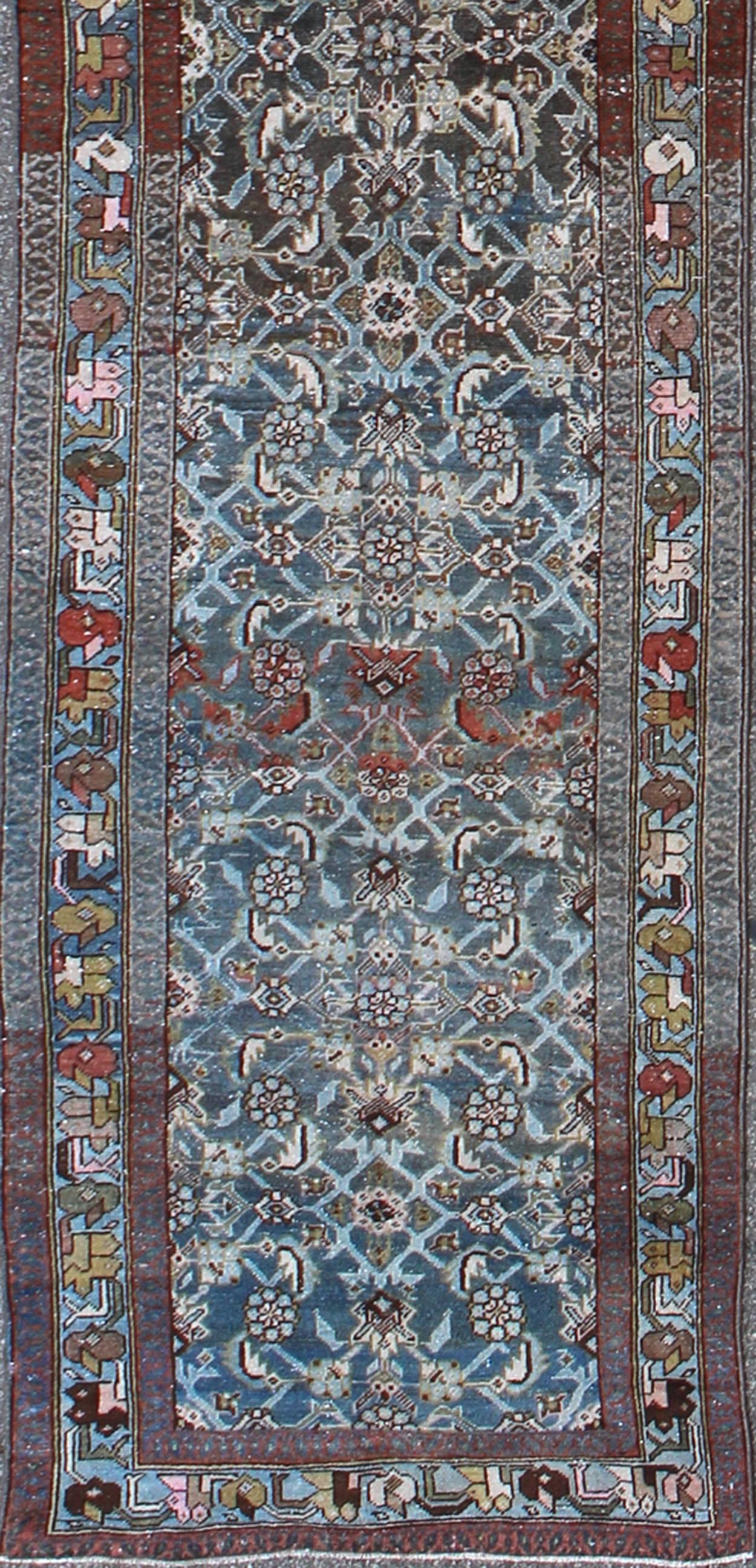 Very Long Kurdish Runner with Dark/Light Blue, Red and Taupe 
sus-259

This Kurdish tribal rug was woven by Kurdish weavers in western Persia in the early 20th century. Often they used this repeating latch-hook design in the border, woven along in